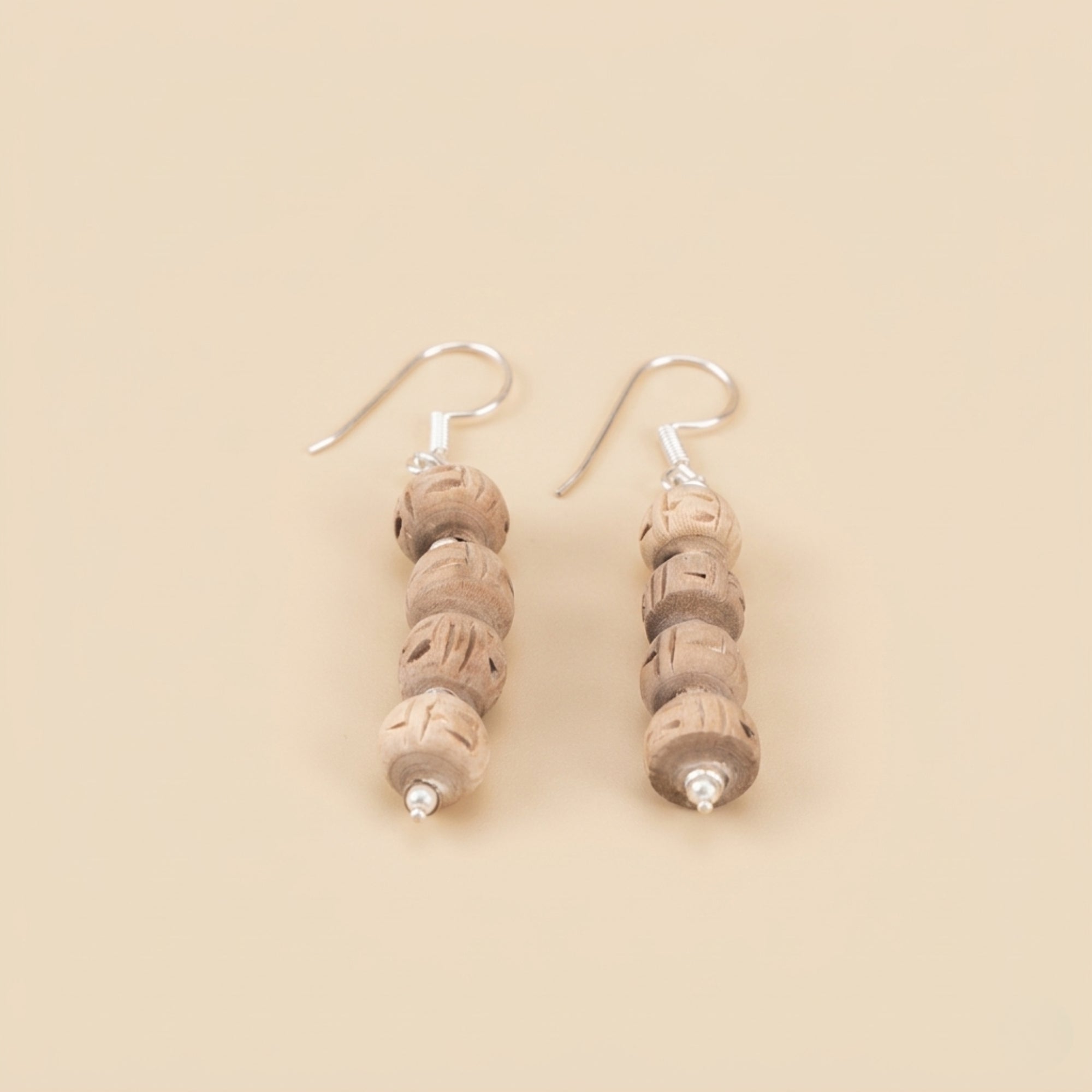 elegant silver dangle earrings featuring four stacked carved Tulsi wood beads
