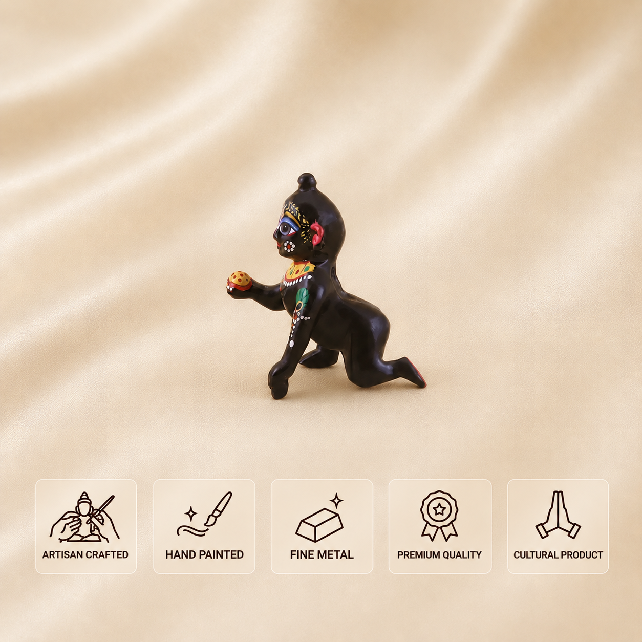 Side view of a hand-painted black Laddu Gopal idol holding a laddu.