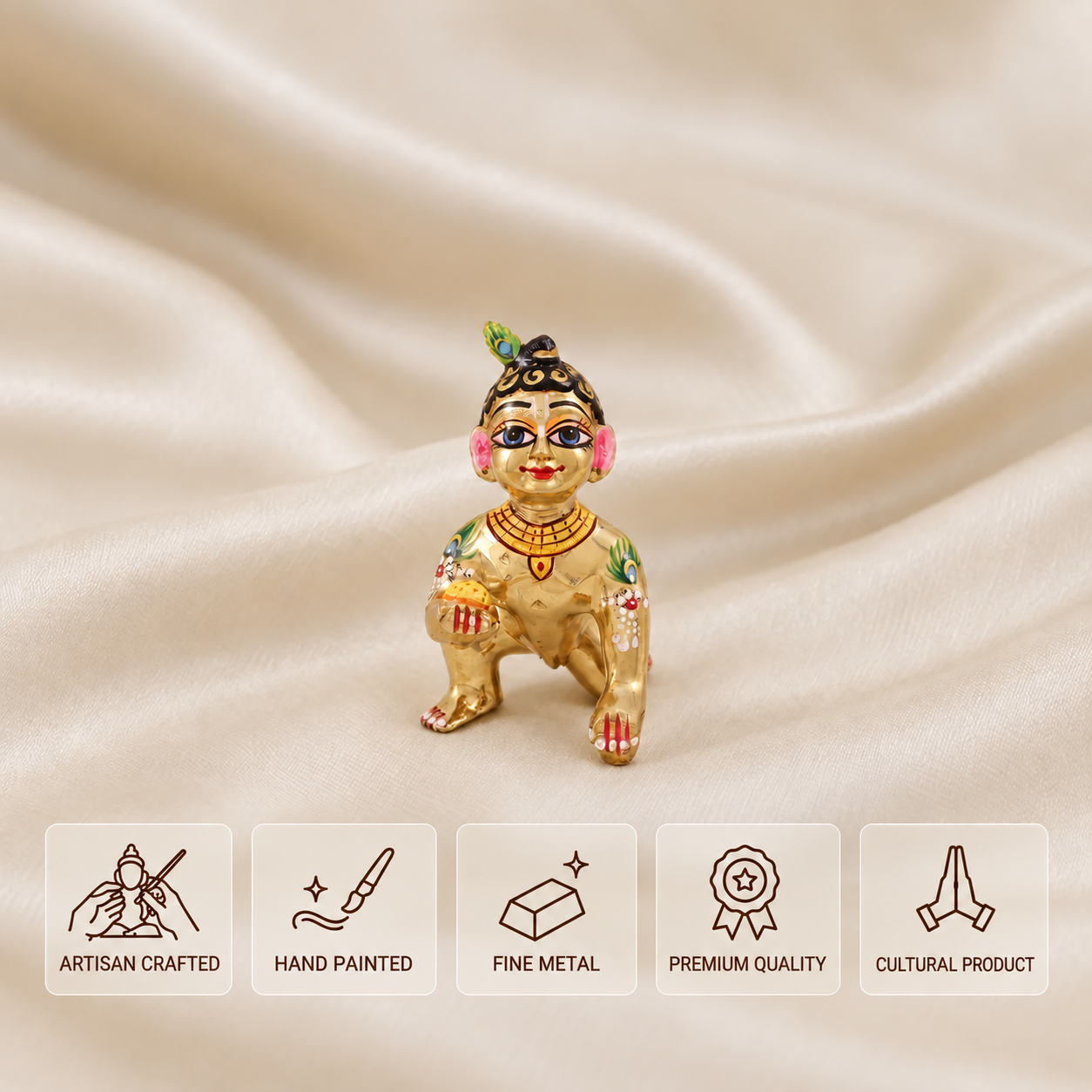 Hand-painted golden crawling Laddu Gopal idol with a peacock feather on cream satin, shown with artisan crafted, hand painted, fine metal, premium quality and cultural product features.