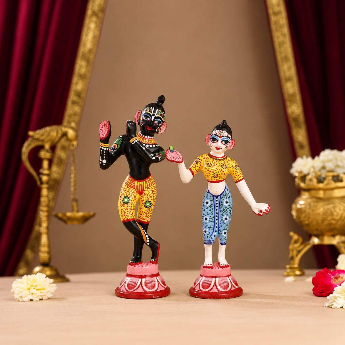 Hand-painted Radha Krishna idols with traditional Indian folk-art detailing on decorative lotus bases