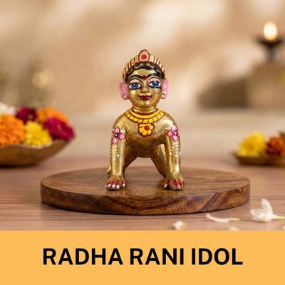 A small, gold-toned Radha Rani idol statue featuring intricate pink, red, and blue painted details.