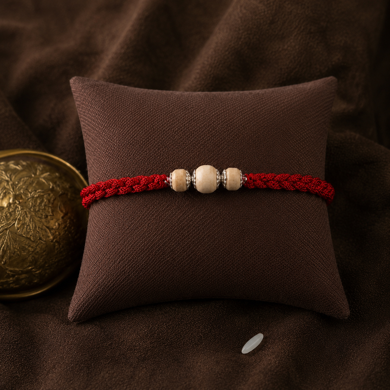 Handcrafted pure silver accent trio Tulsi wood sacred rakhi displayed on brown cushion
