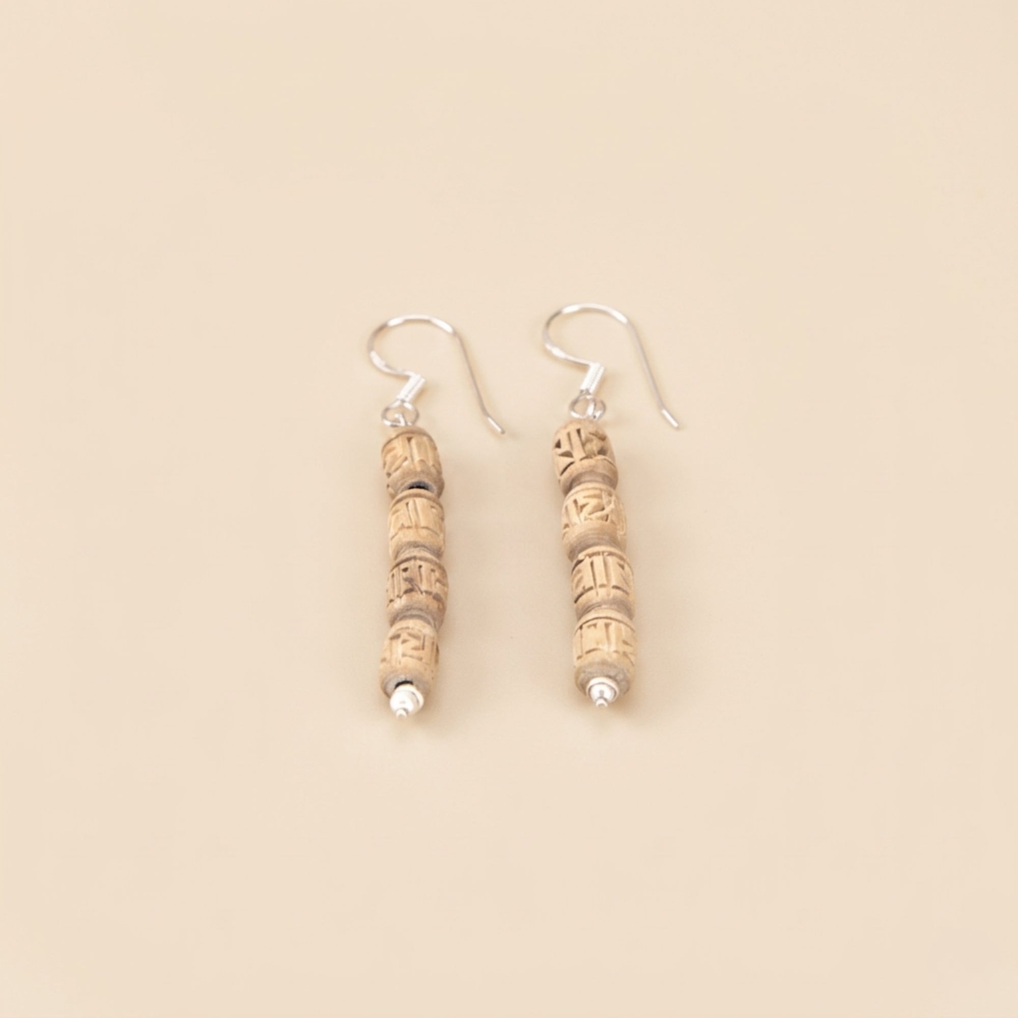 handmade silver dangle earrings featuring carved Tulsi wood beads