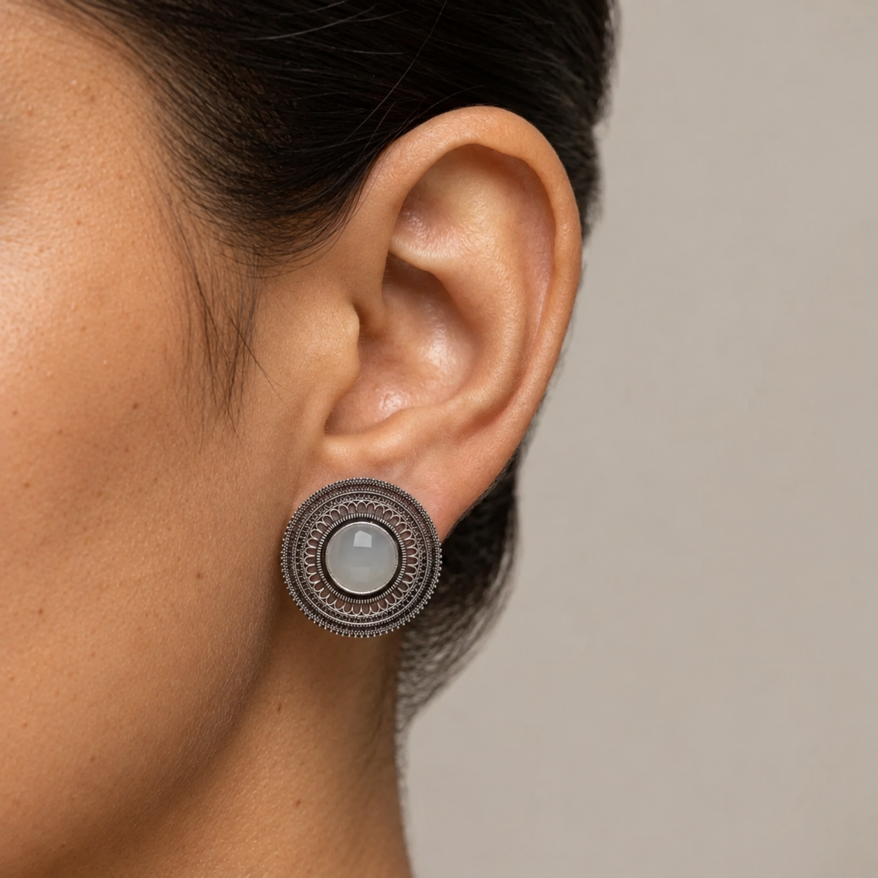 A round imitation filigree earring with a milky white centre stone