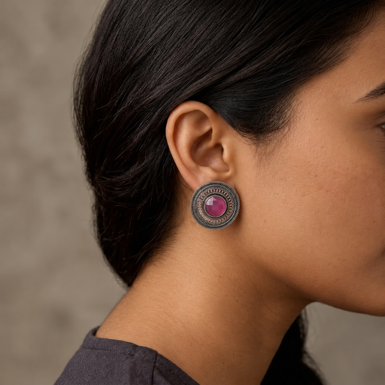Model wearing a round imitation filigree earring with a pink centre stone