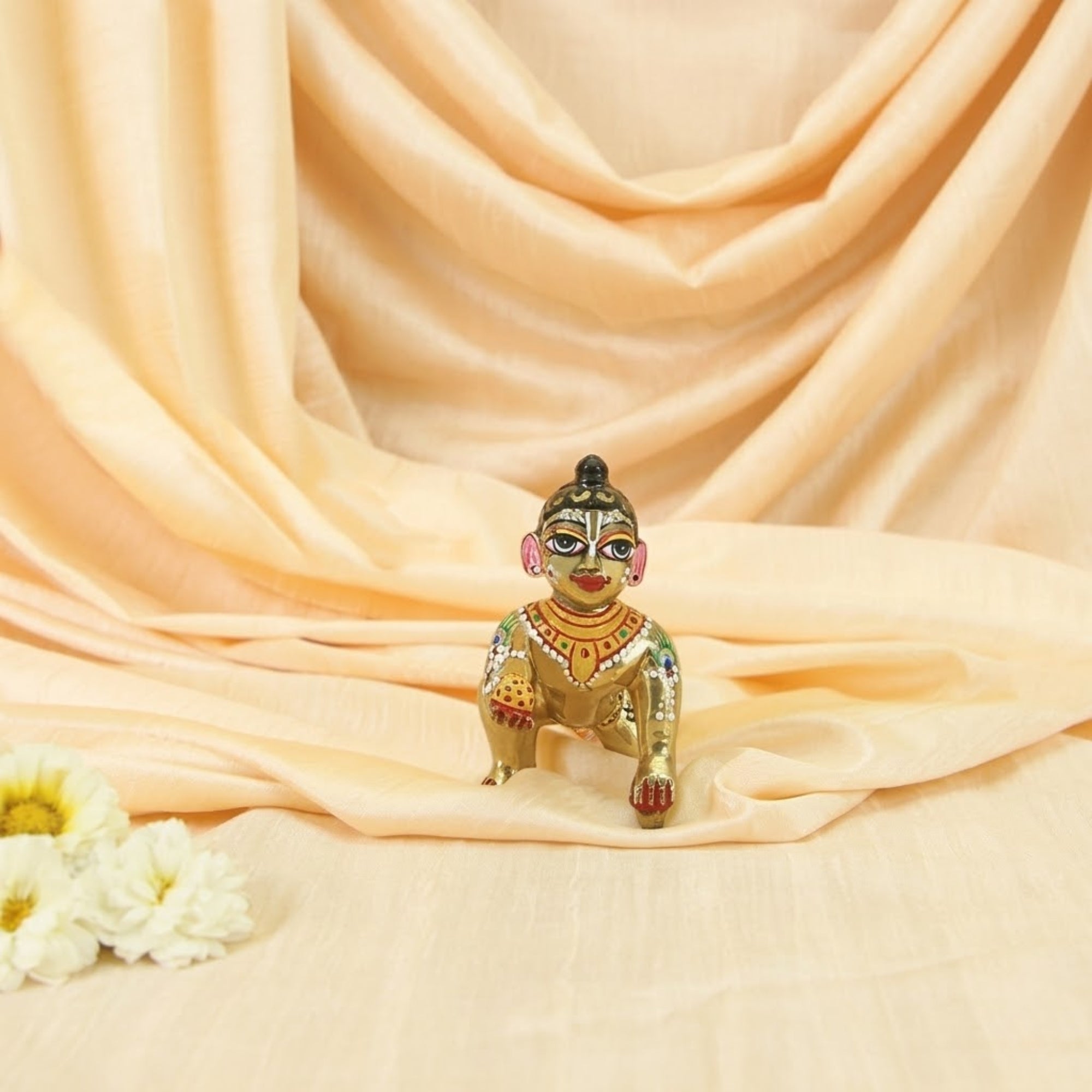 Decorative Shringar Laddu Gopal Ashtadhatu idol displayed on a soft silk backdrop
