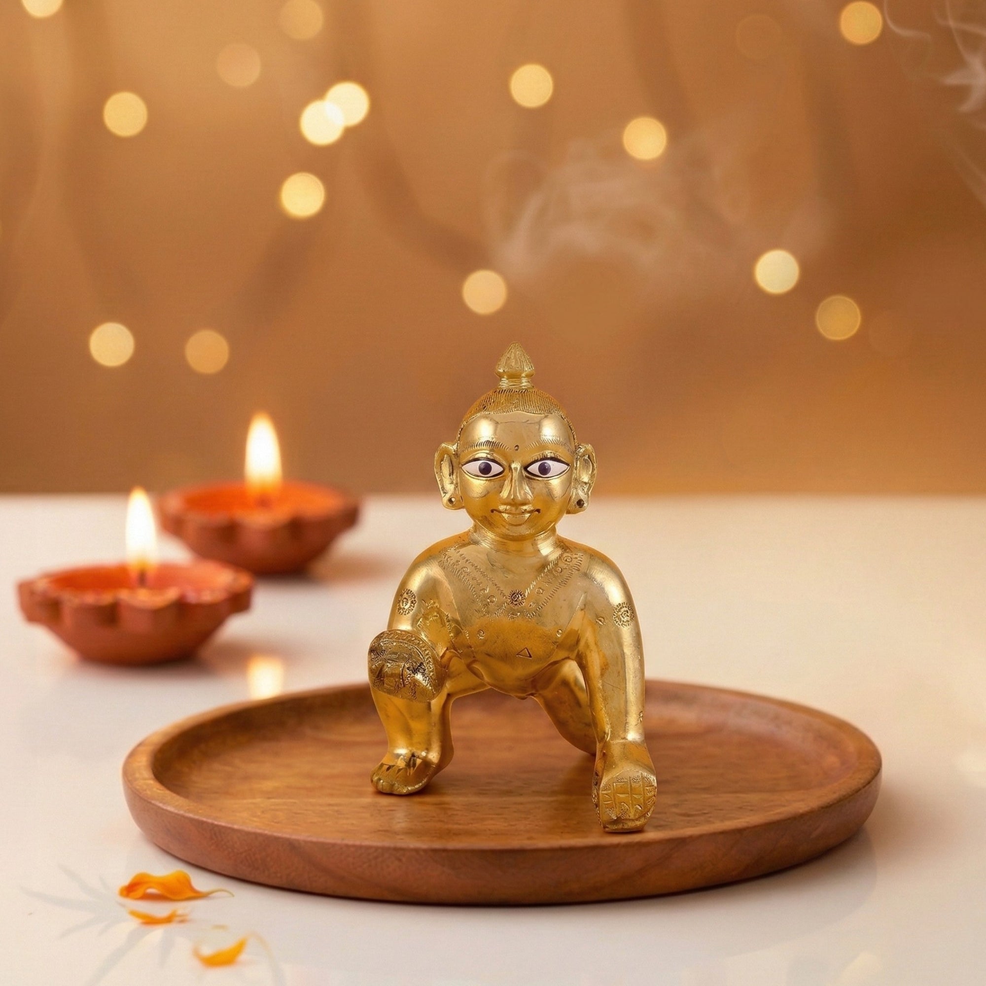 Plain design Bal Gopal Ashtadhatu idol of Laddu Gopal displayed on a wooden tray with diyas