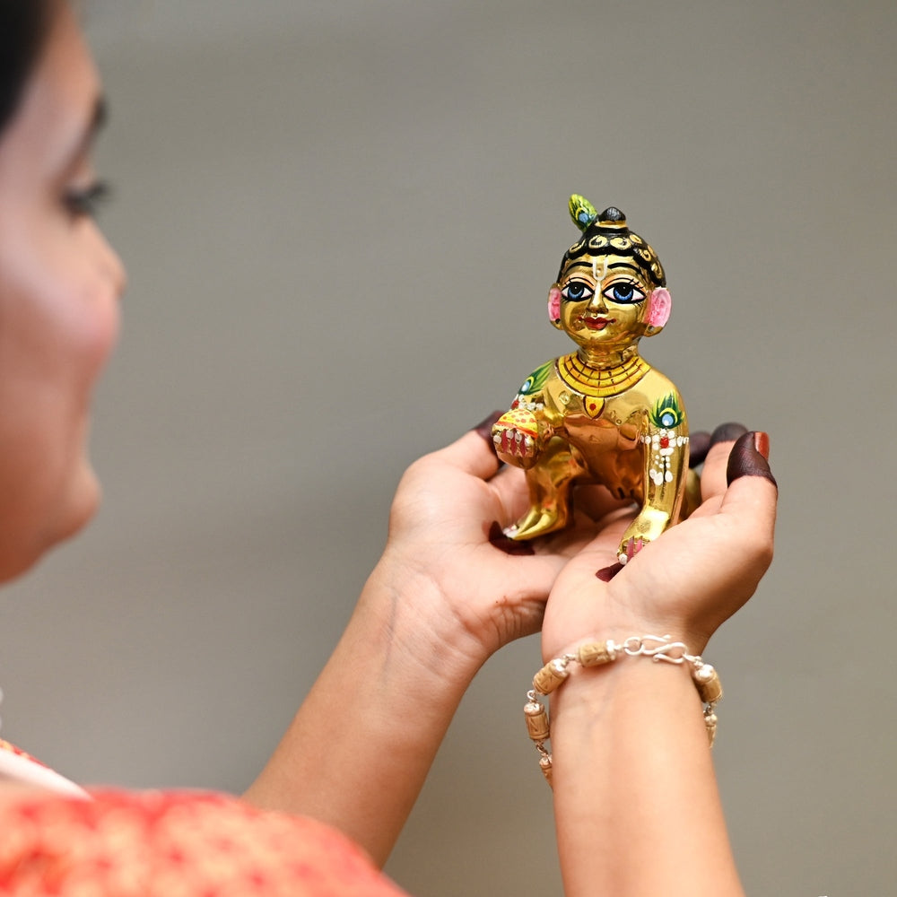 Solid weighted Ashtadhatu Laddu Gopal idol of Thakur Ji held in hands showing premium scale