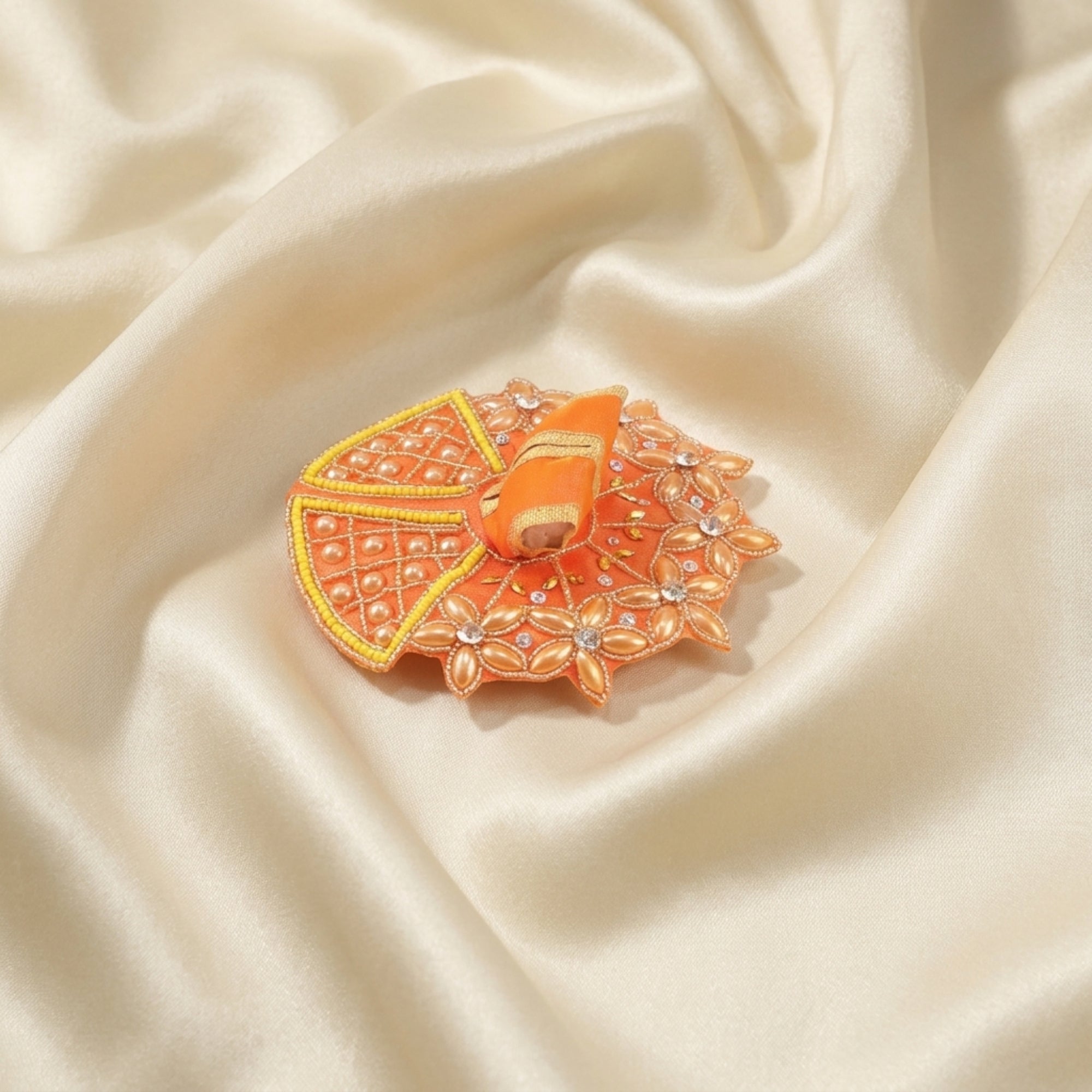 Laddu Gopal orange dress with handcrafted golden floral design displayed flat
