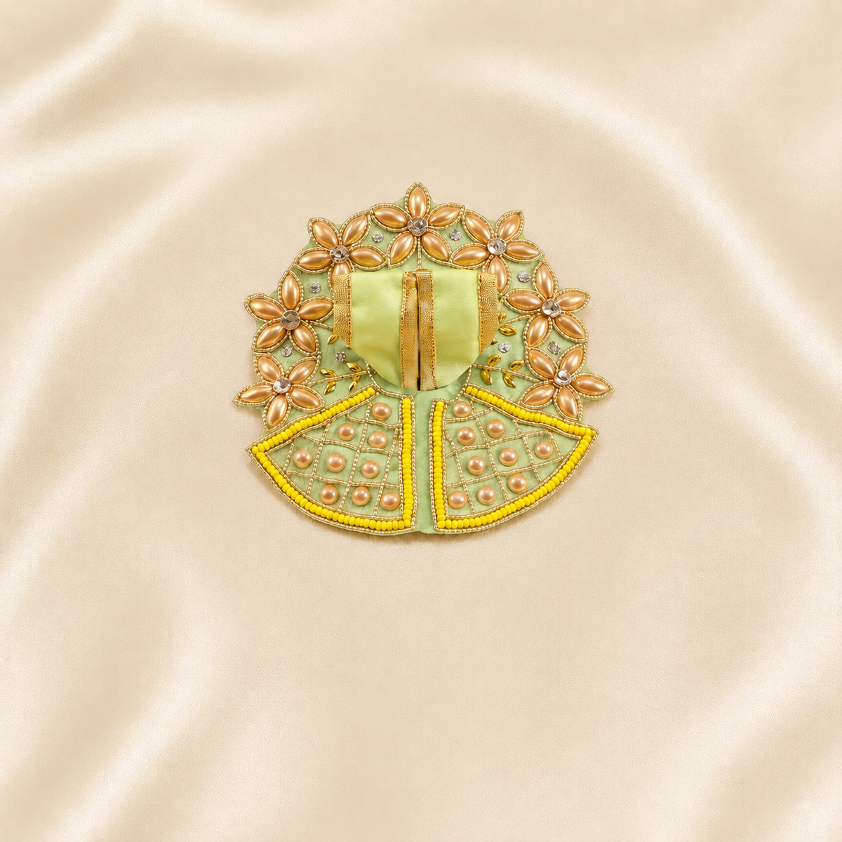 Light green Laddu Gopal dress with large golden flowers and pearl detailing.