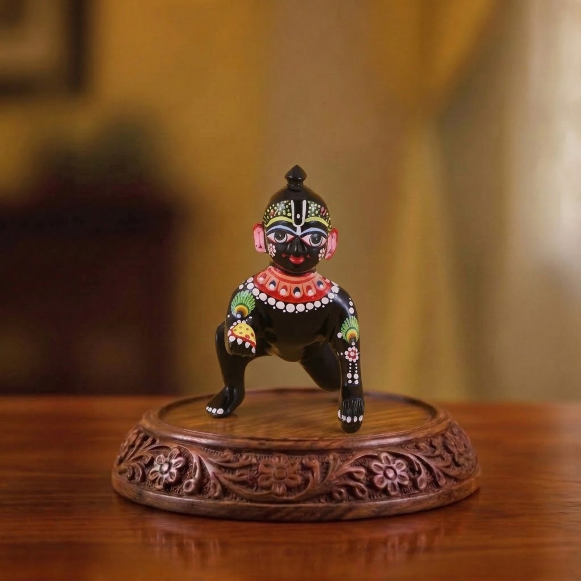 Little black Laddu Gopal brass idol with beautiful Shringar displayed on a wooden base