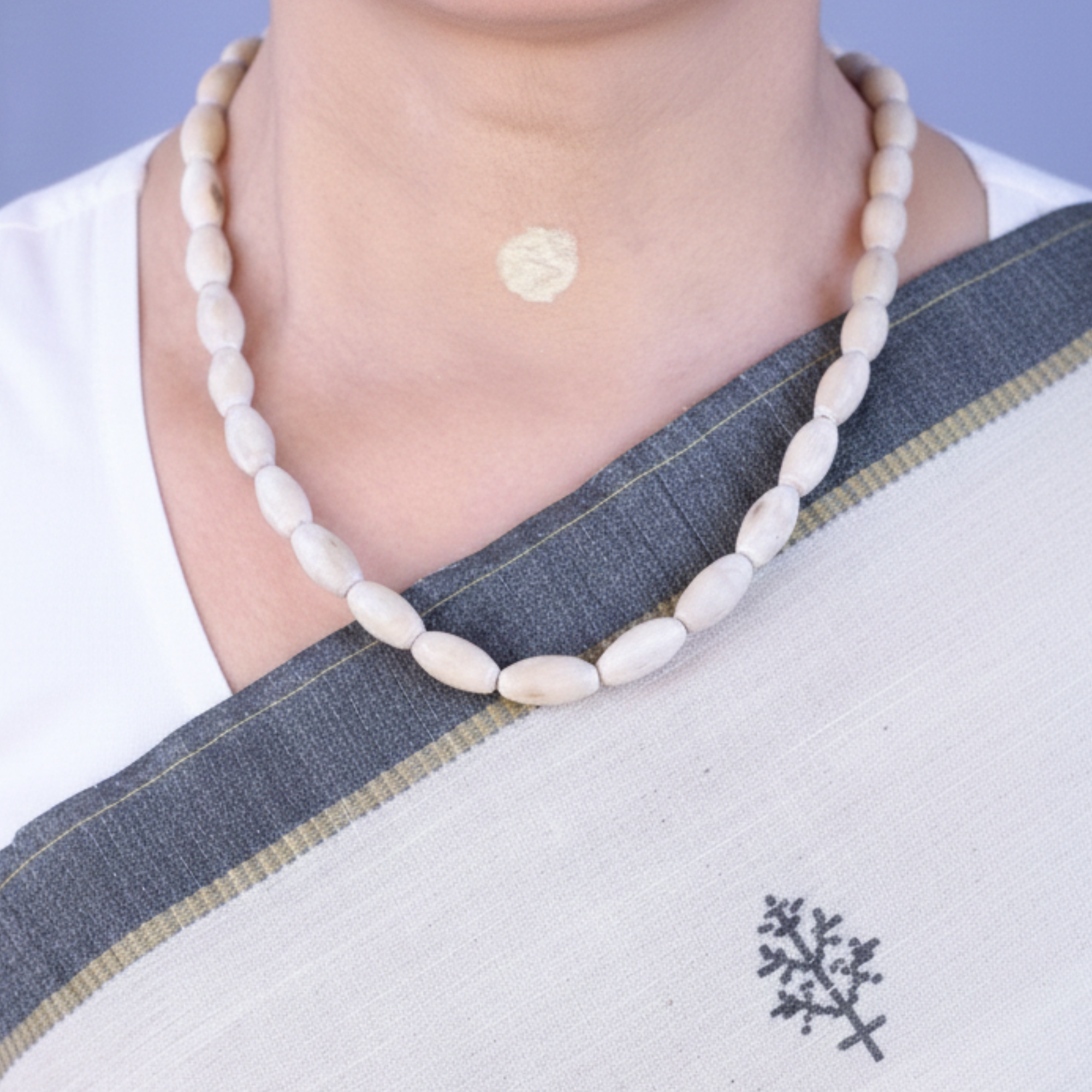 Woman wearing an original Mathura Tulsi Kanthi Mala necklace with oval shaped wood beads