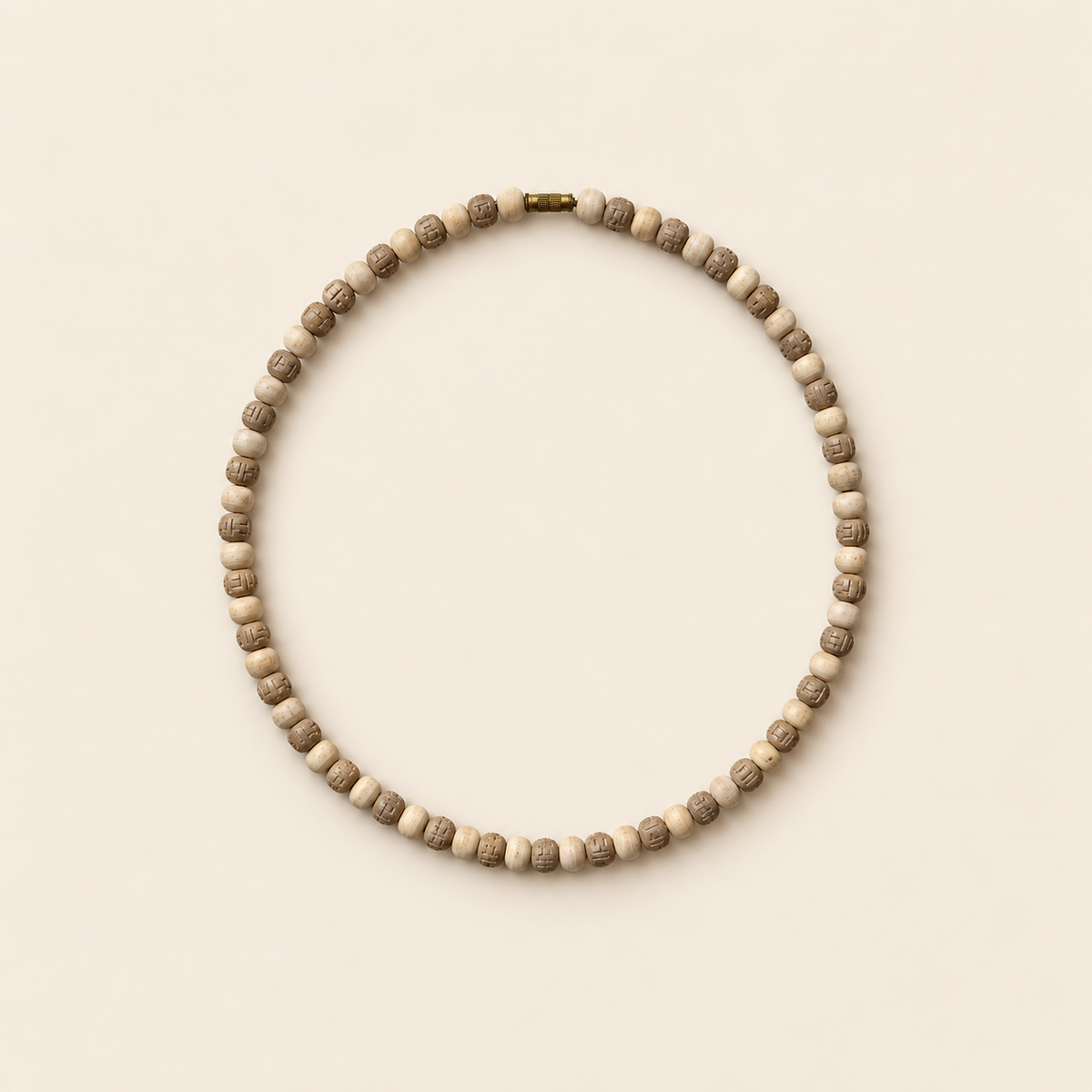 Tulsi wood mala with pale plain beads, brown carved beads and a brass screw clasp on a cream background.