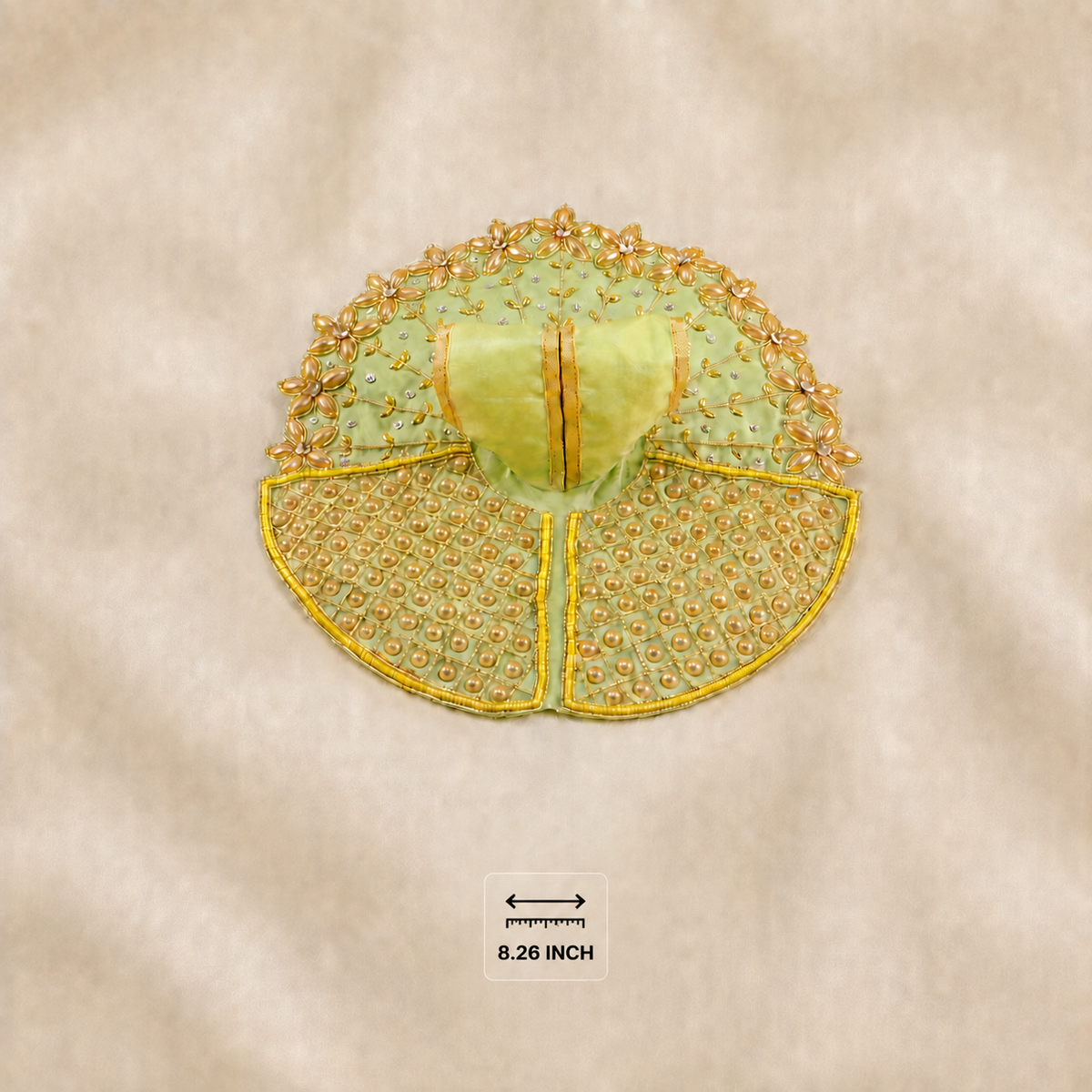 A small embroidered decorative applique or patch in pale yellow-green and gold, shown flat on a beige fabric background with an 8.26 inch size marker below it.