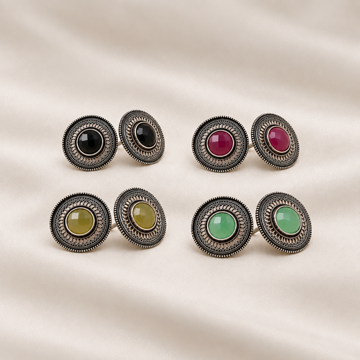 Four pairs of oxidised metal imitation stud earrings in black, pink, yellow and green