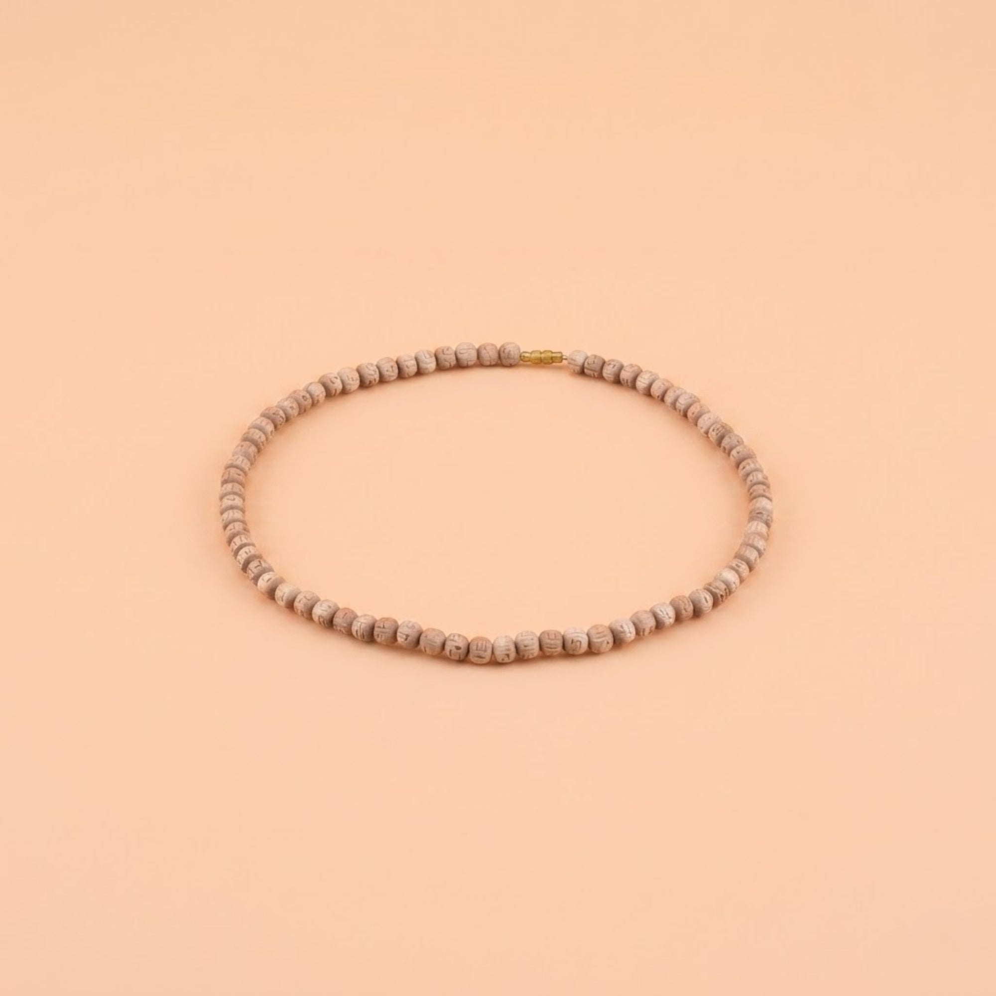 Close up of premium 10mm hand-carved wooden round beads with a natural finish on a Tulsi kanthi mala