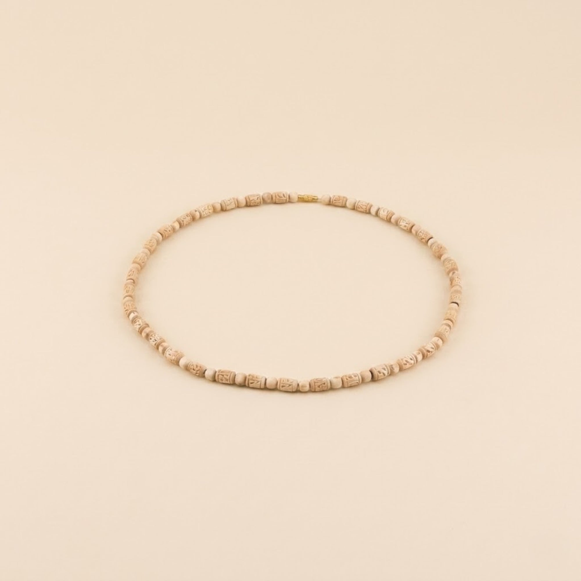 Close up of pure wooden beads hand-carved with the name Radha with a natural finish on a Tulsi kanthi mala