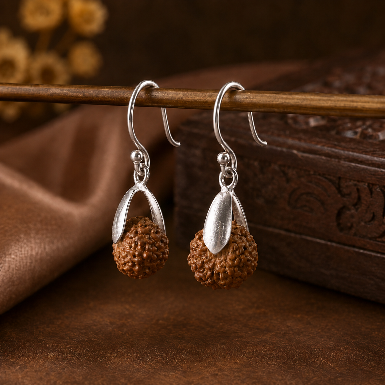 Close-up view of natural Rudraksha bead and pure silver cap on dangle earrings