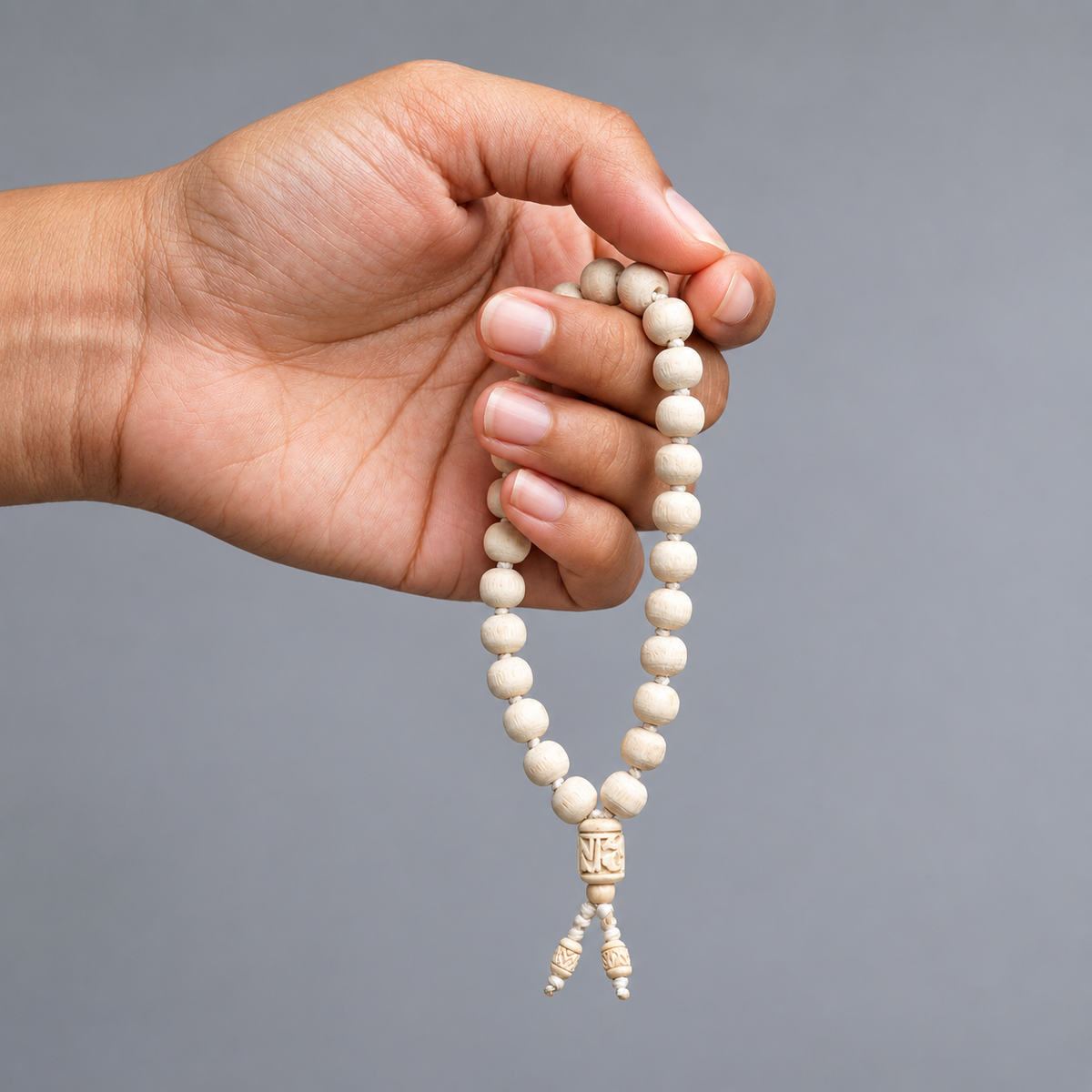 Natural Tulsi Mala with 10 mm original Tulsi beads and 12 inch length shown in hand by merekrishna.in