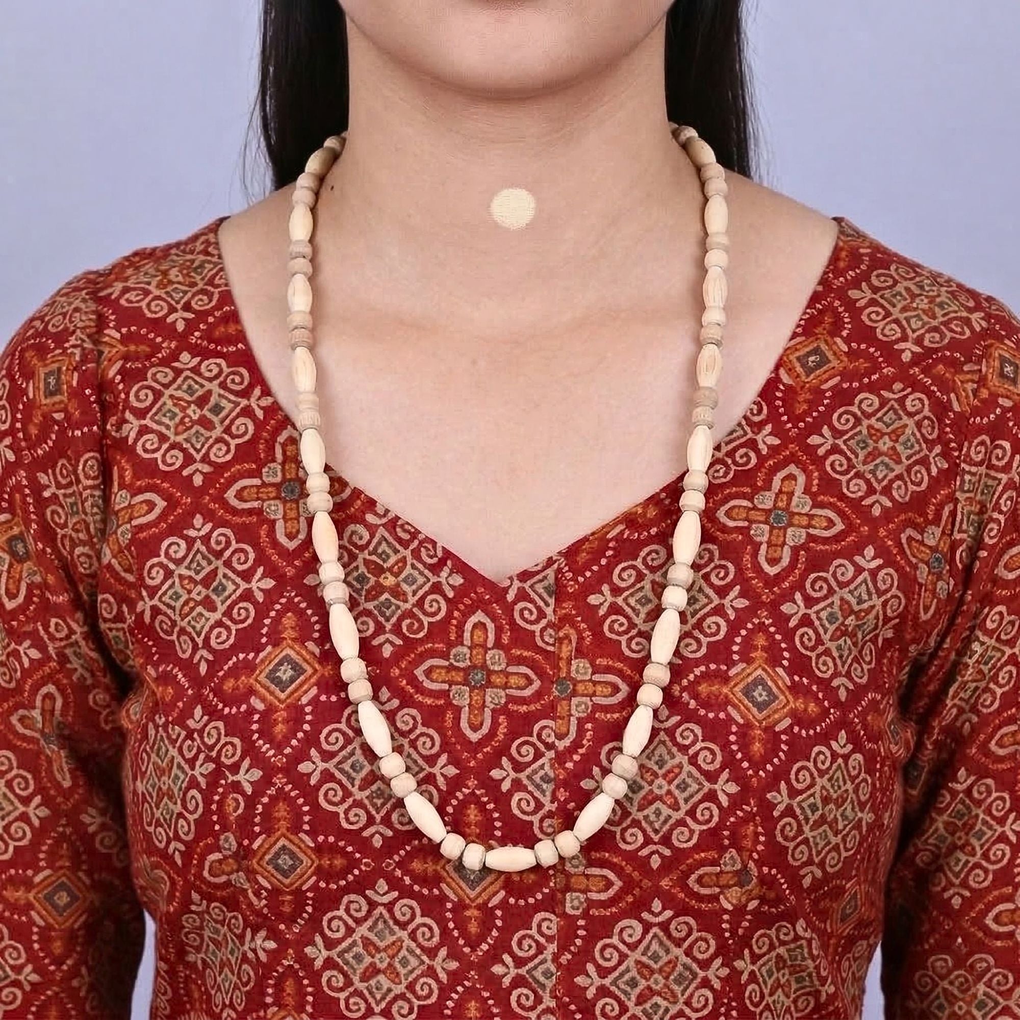 Woman wearing an original Tulsi Kanthi Mala necklace featuring smooth oval beads