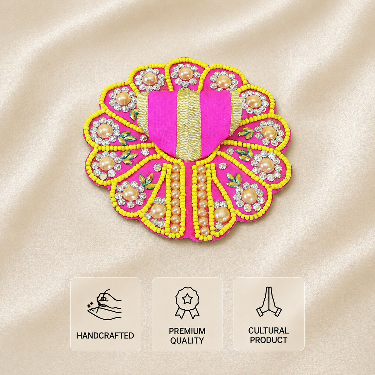 Pink Laddu Gopal dress with yellow beadwork, pearl floral embellishments, rhinestone details and gold trim on an ivory satin background.