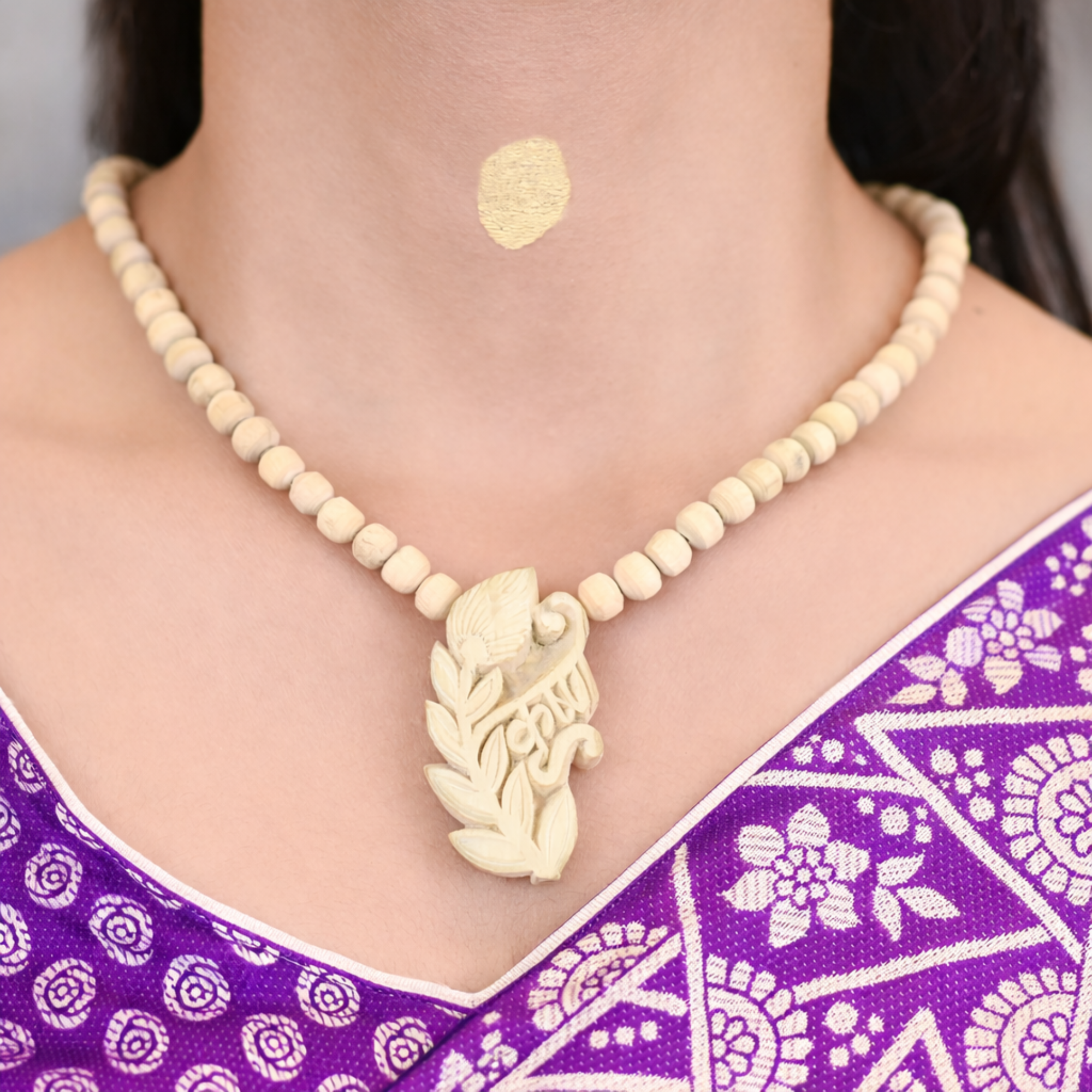 Woman wearing a premium pure Tulsi kanthi mala with an intricately carved Lord Krishna pendant