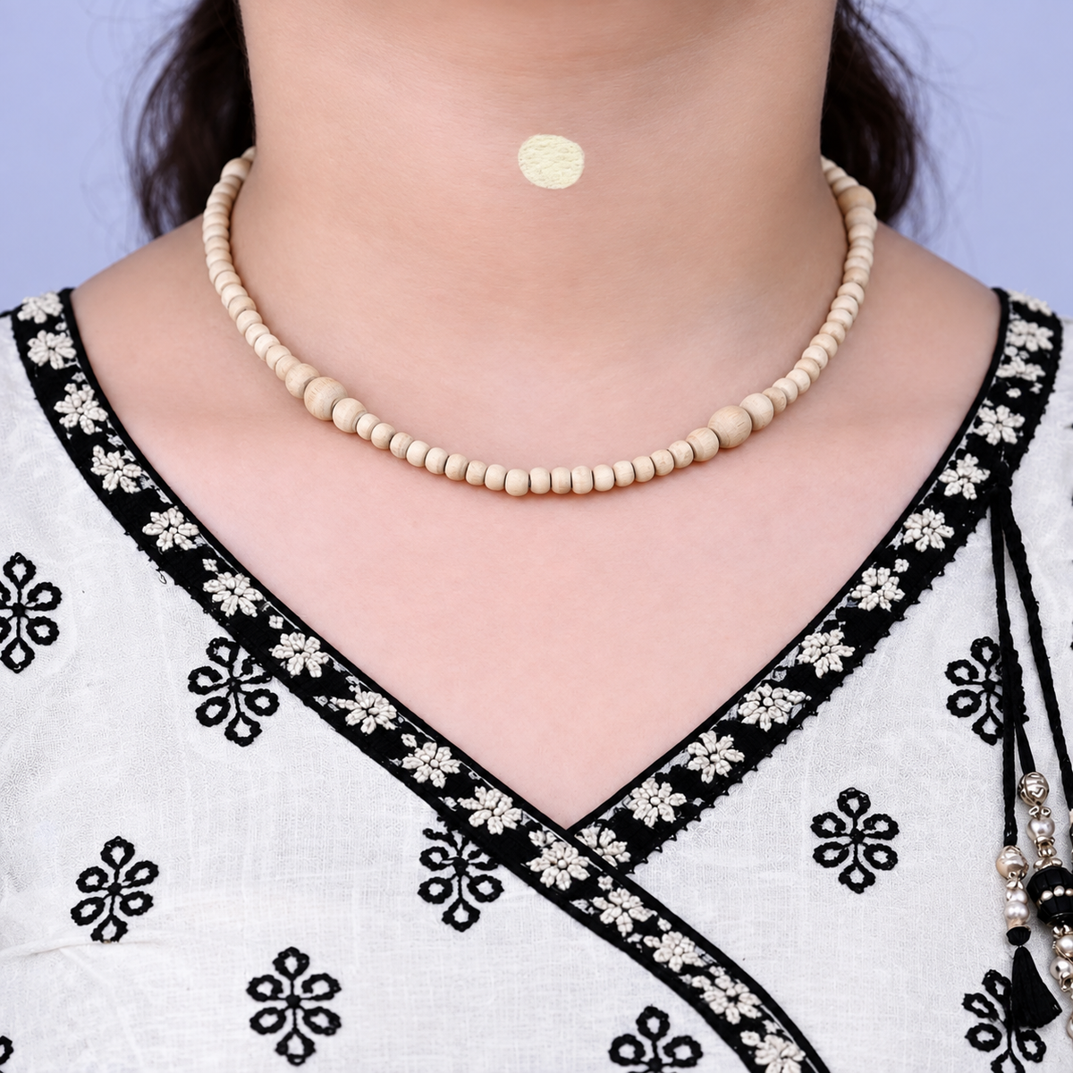 Woman wearing pure original Tulsi Mala necklace made with natural handmade Tulsi beads in a close-up neck shot.