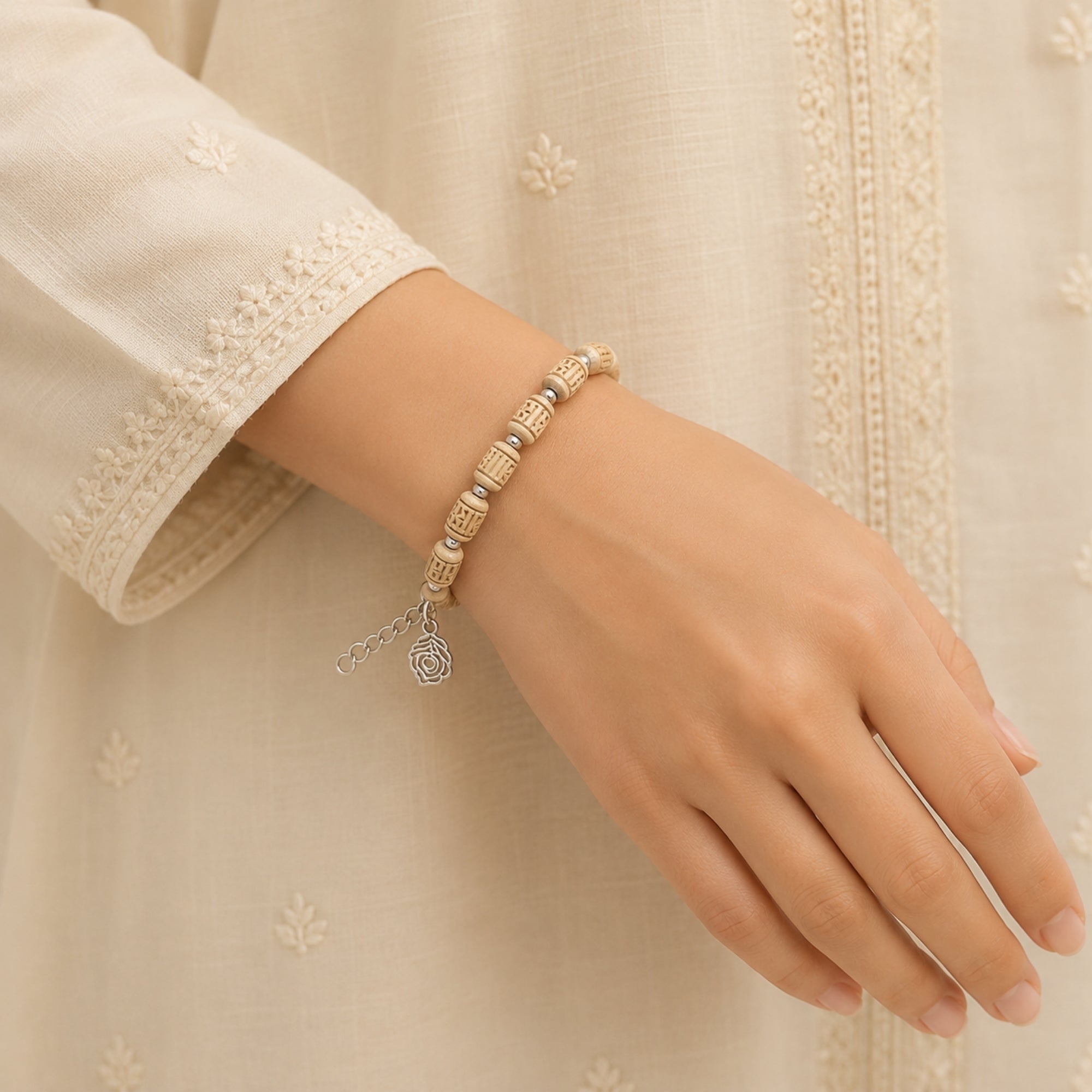 Person wearing a pure Tulsi wood bead bracelet featuring a silver Morpankh charm