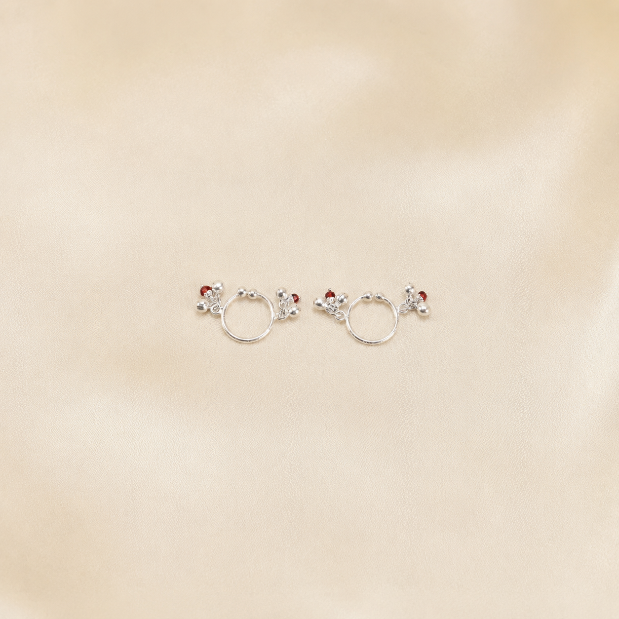 Pair of pure 925 silver ghungroo payal anklets for Laddu Gopal displayed on cream silk fabric
