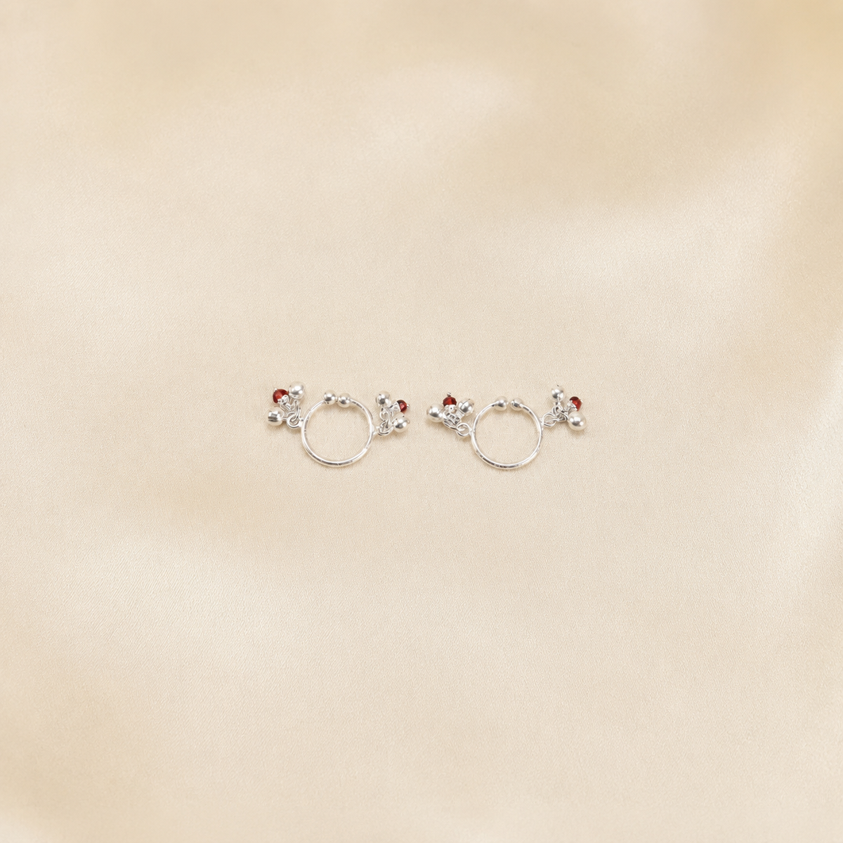 Pair of pure 925 silver ghungroo payal anklets for Laddu Gopal displayed on cream silk fabric