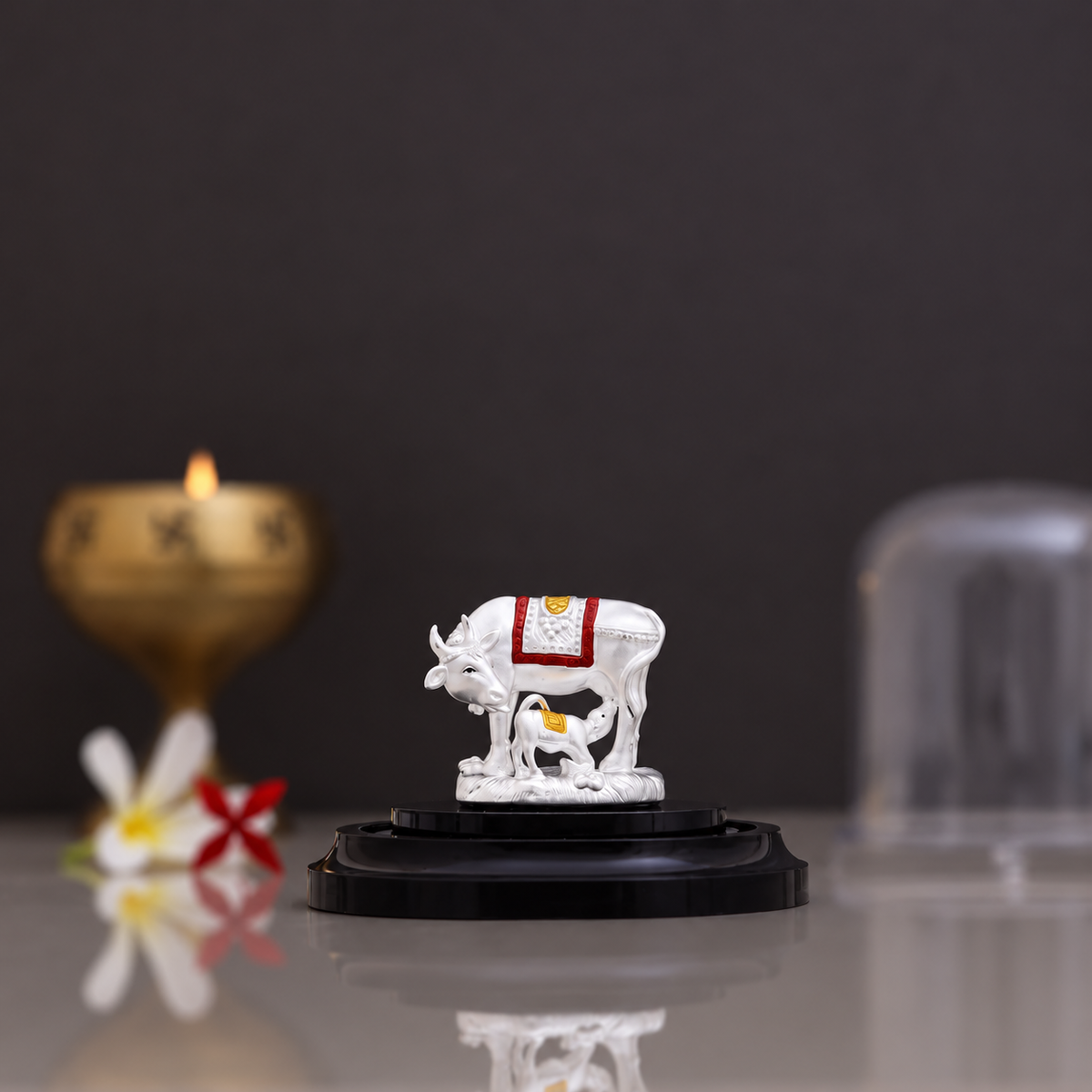 Silver Kamdhenu cow and calf idol with red and gold detailing