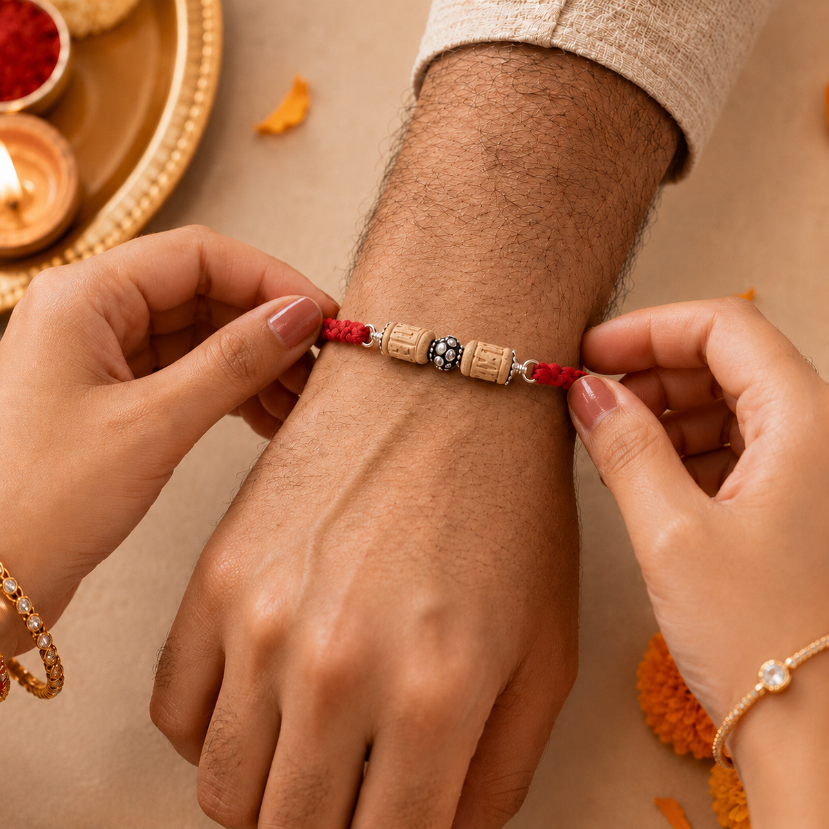 Hands tying pure silver carved Tulsi bead rakhi bracelet on brother wrist for Raksha Bandhan