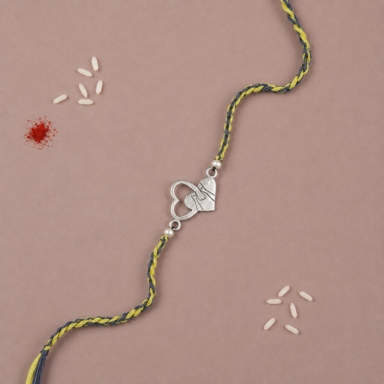 Pure silver dual interlocking heart charm rakhi on yellow and black braided cord
