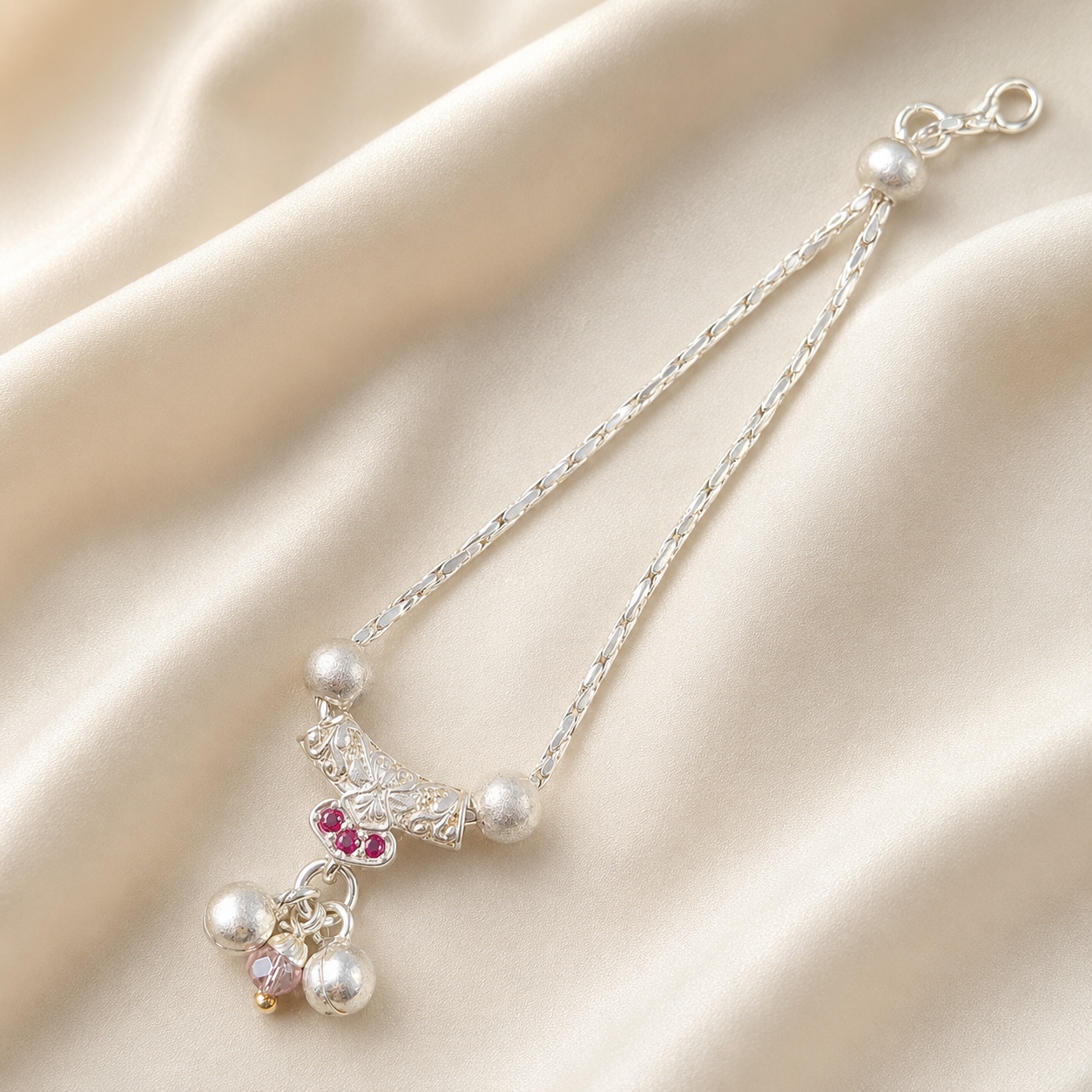 Pure silver necklace for deity idols with pink stones and pearl drops on cream silk fabric