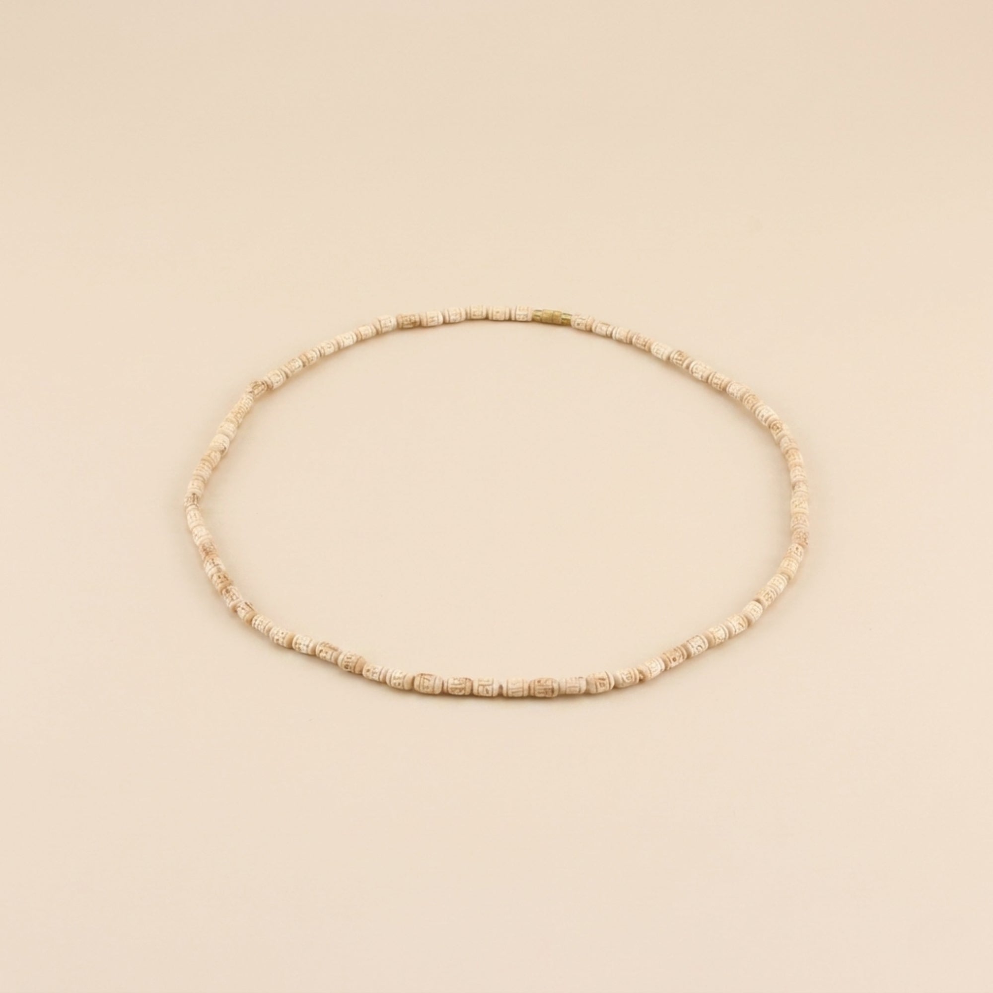 Close up of pure wooden cylindrical beads hand-carved with the name Radha on a Tulsi kanthi mala