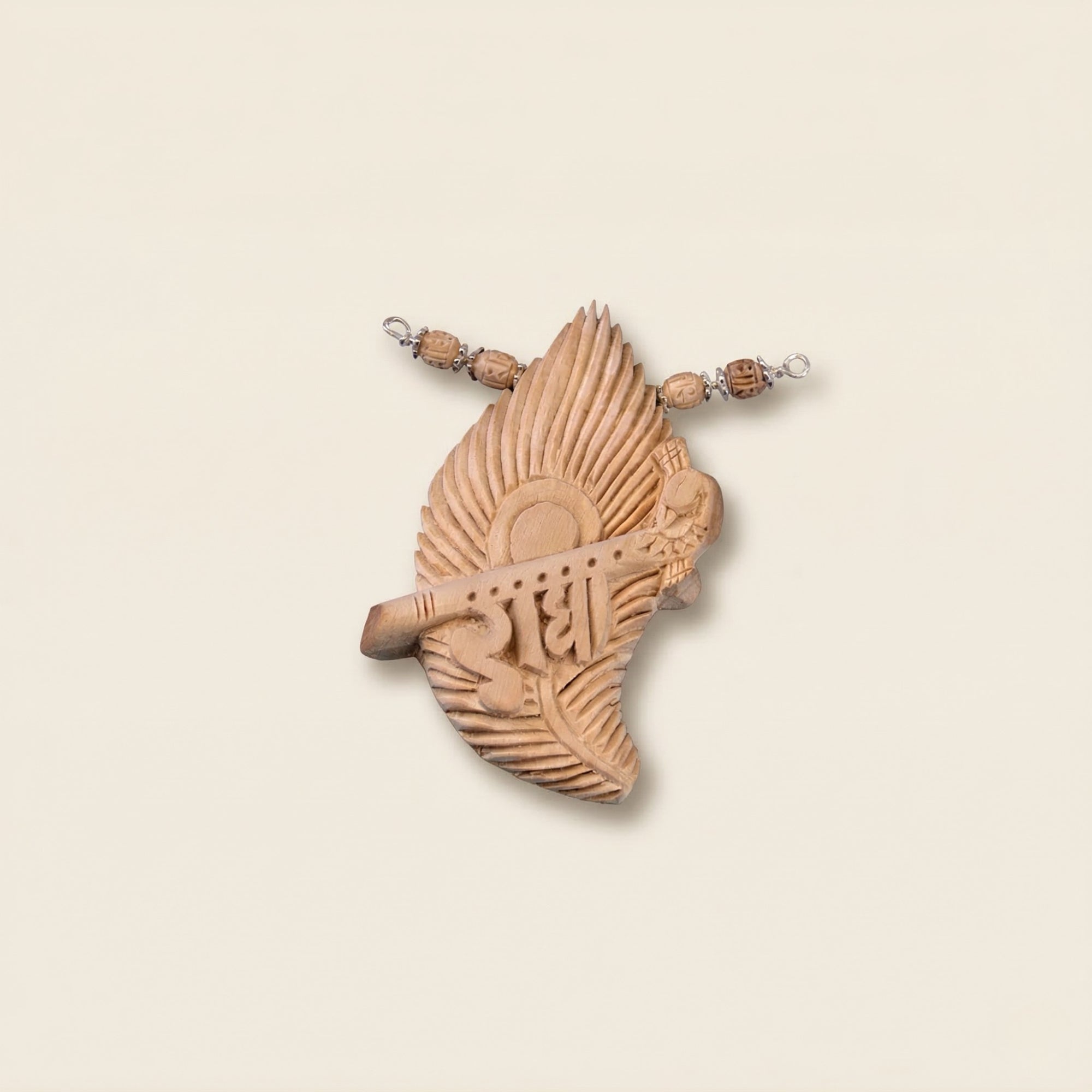 Close up flat lay of a silver pendant featuring authentic Tulsi wood carved with a peacock feather and Radha name