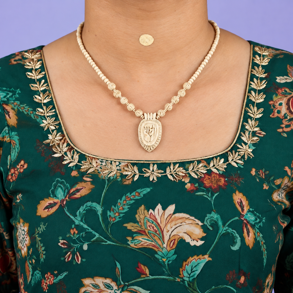 Tulsi mala with carved beads and a Radha name pendant worn with a green floral kurta.