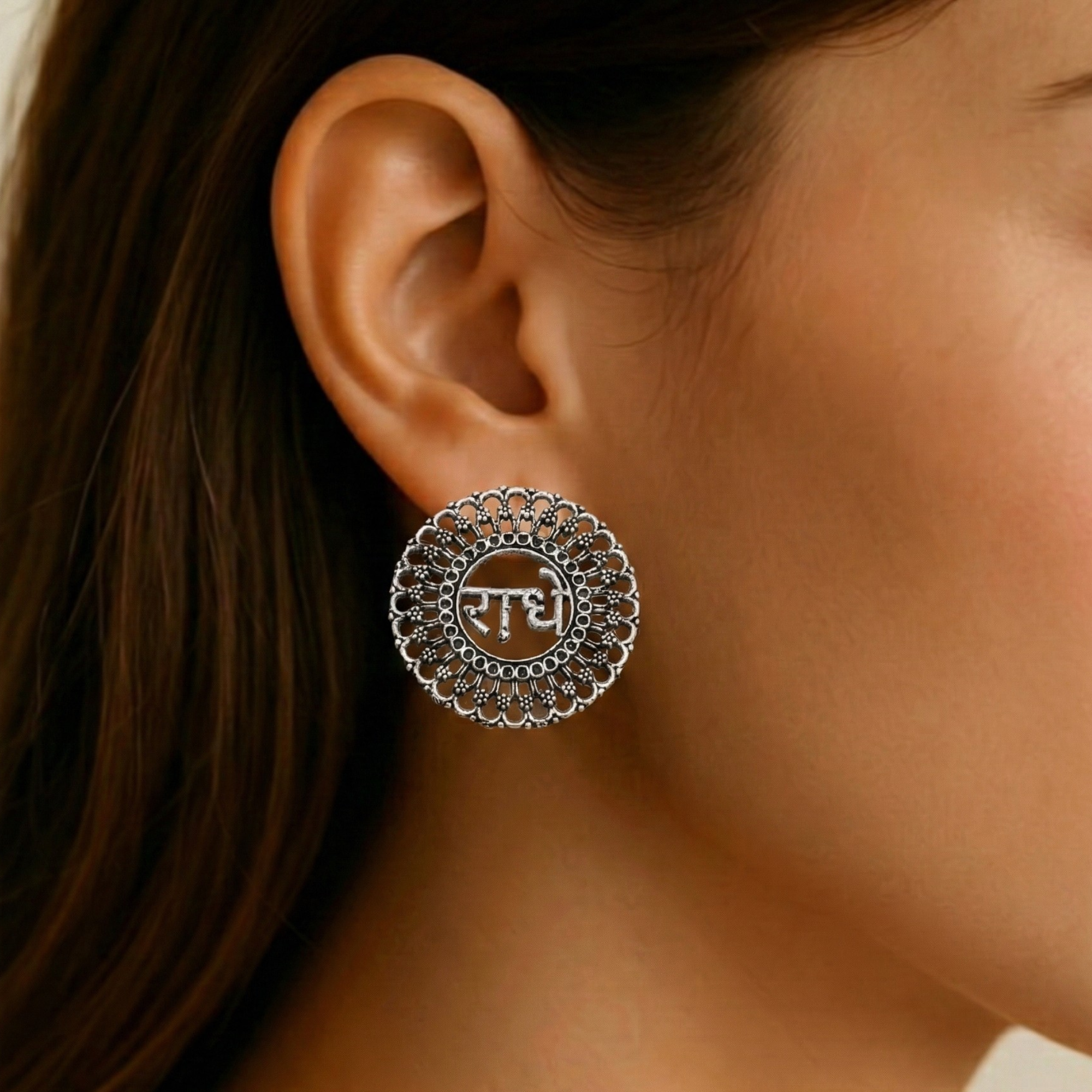 Radha oxidized silver-tone round stud earring with intricate design worn on ear