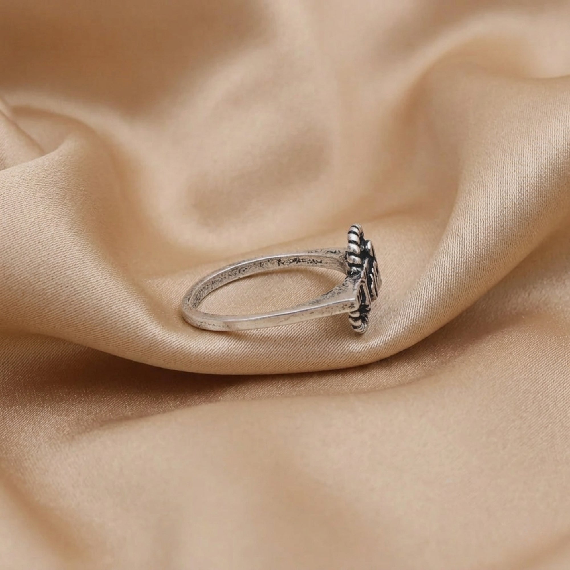 Side view showing adjustable band construction of Radha name oxidized ring