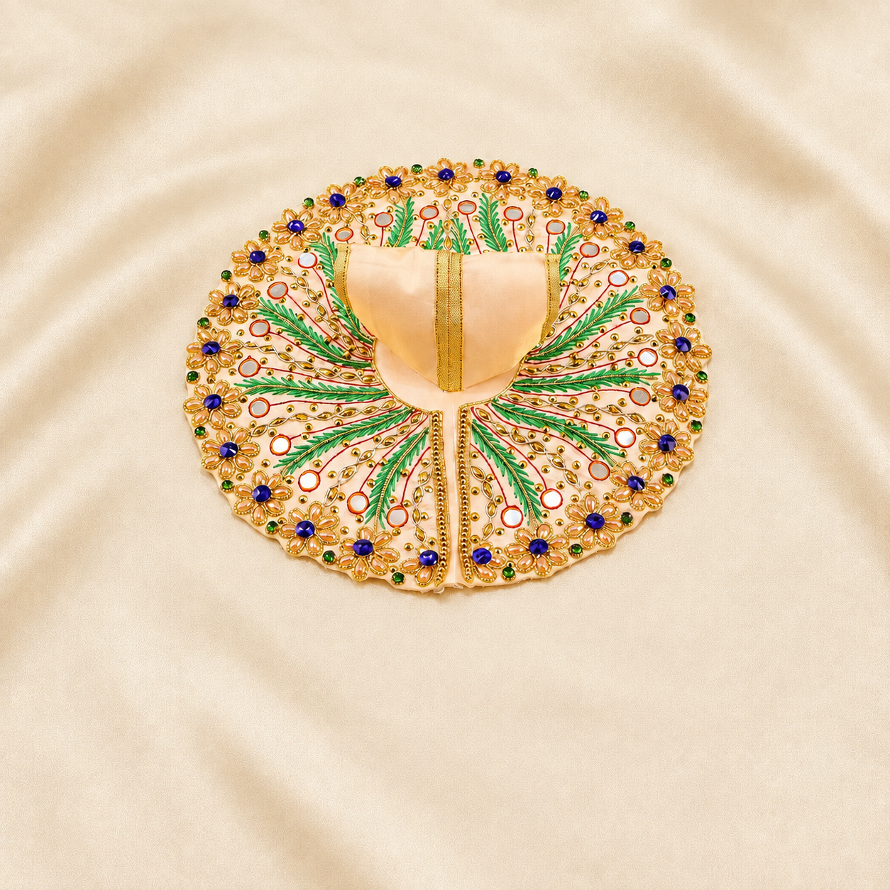 Cream Laddu Gopal dress with green leaf embroidery and blue floral stones.