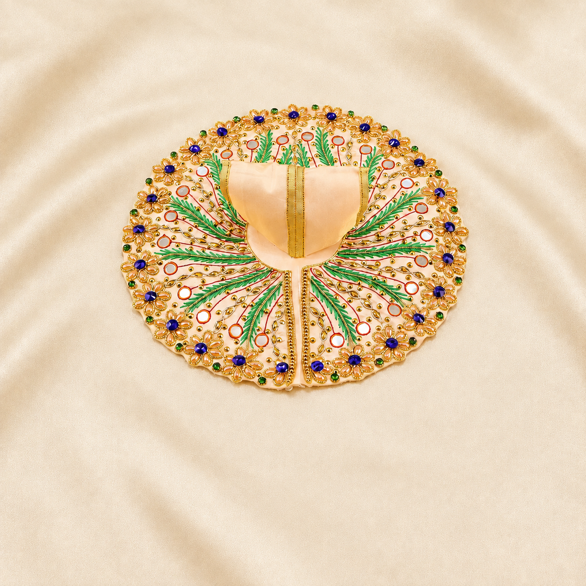 Cream Laddu Gopal dress with green leaf embroidery and blue floral stones.