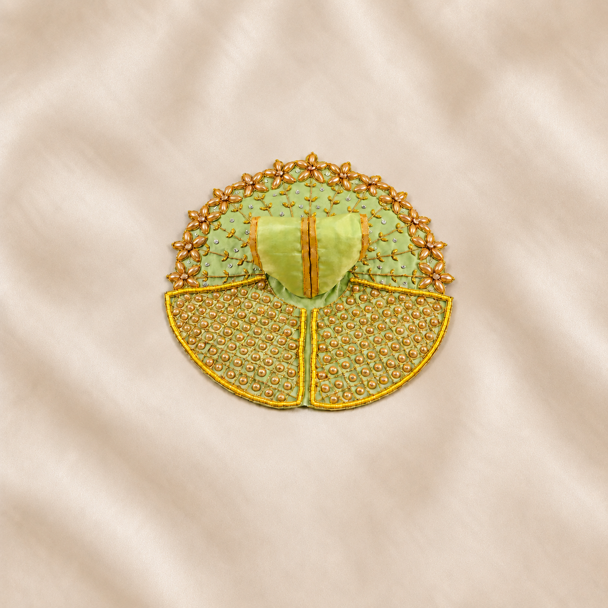 Green and golden embellished Laddu Gopal poshak with floral detailing and pearl beadwork