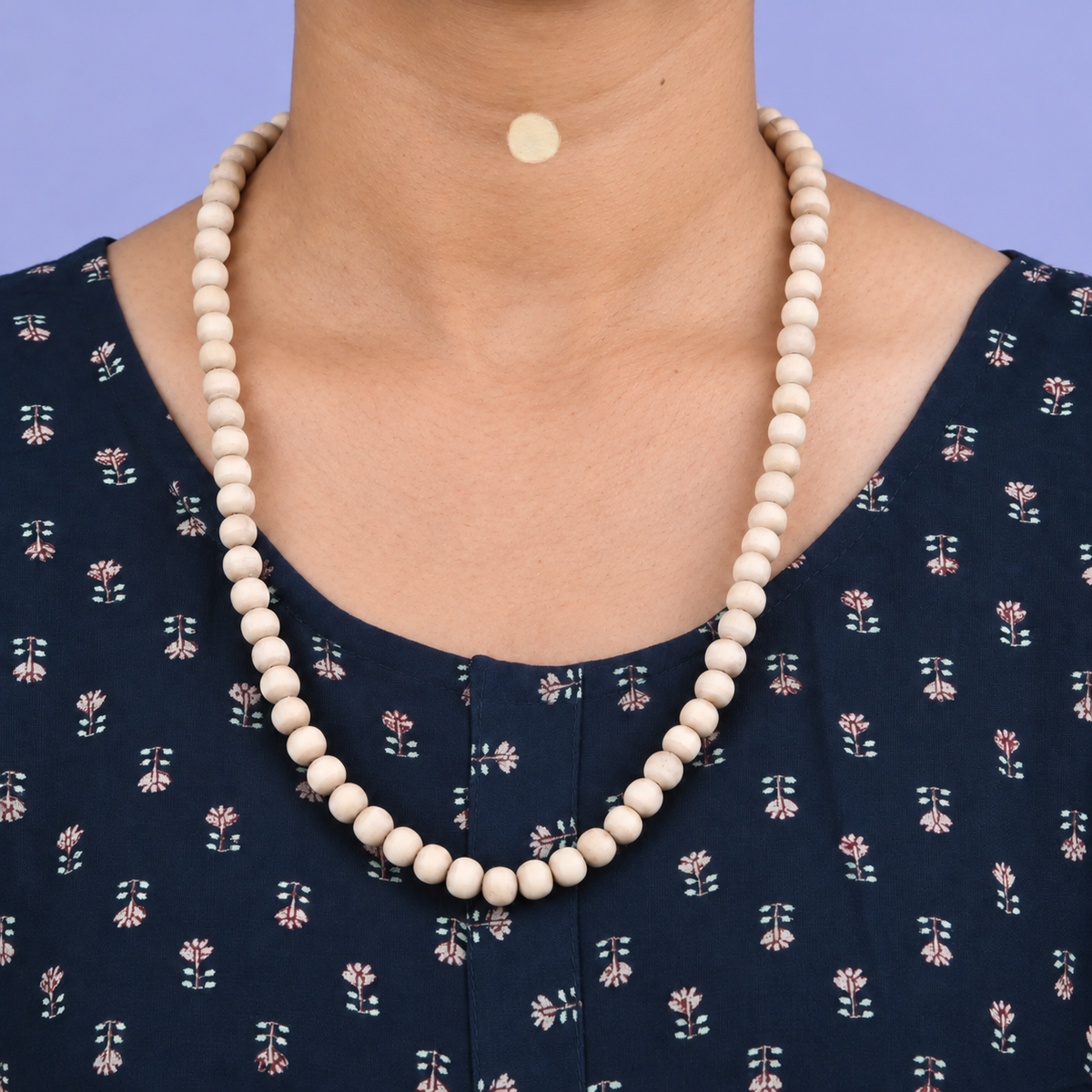 Tulsi mala with smooth round wooden beads worn with a navy floral kurta.