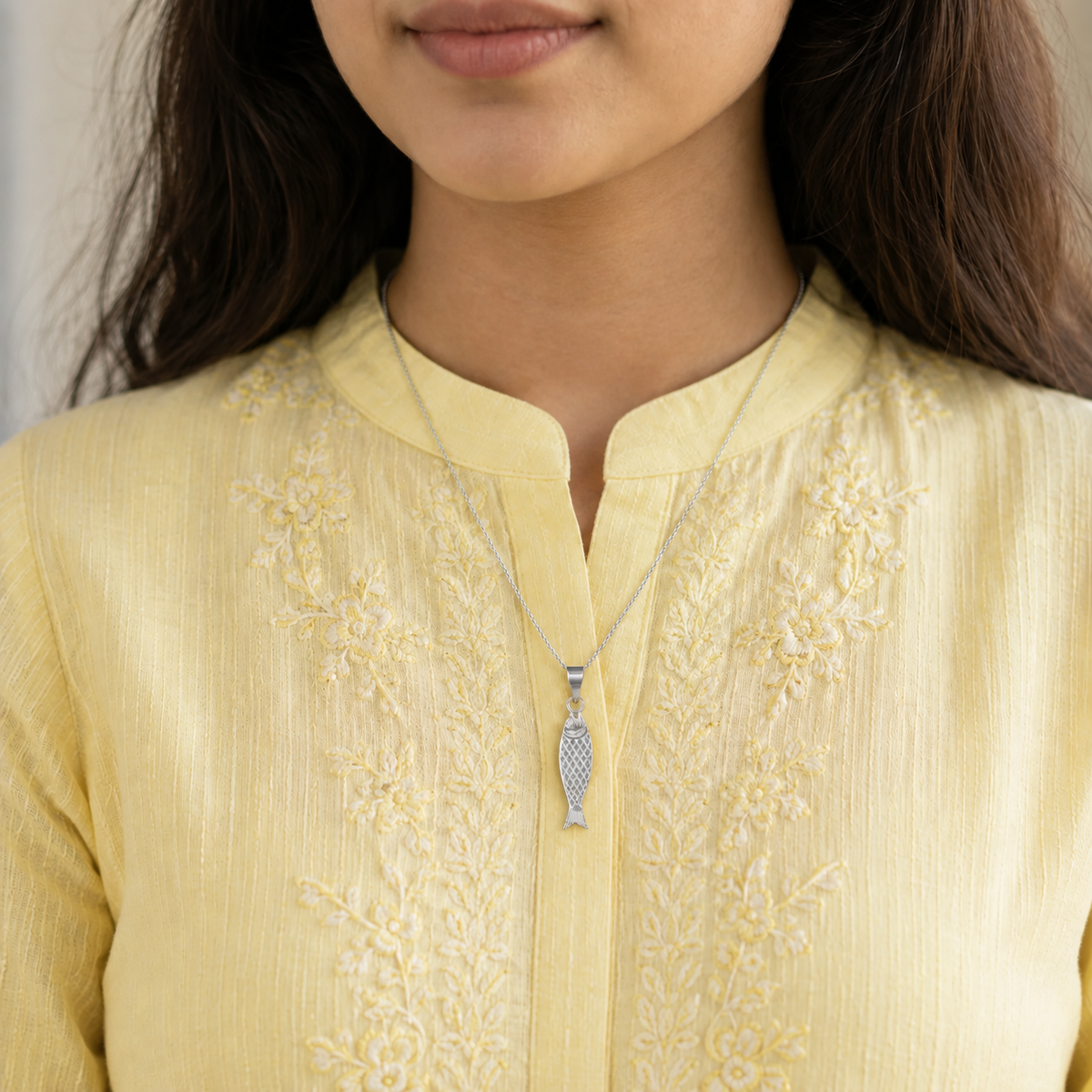 Woman wearing a silver fish pendant necklace 
