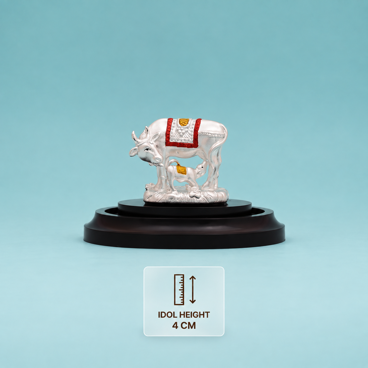 Silver Kamdhenu cow and calf idol with red and gold detailing