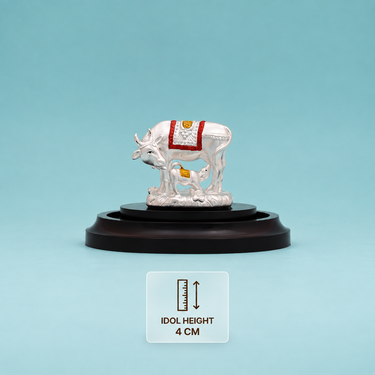 Silver Kamdhenu cow and calf idol with red and gold detailing