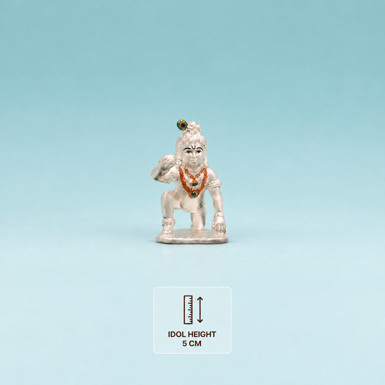 Silver Laddu Gopal idol, 5 cm high, with orange and green ornament details.