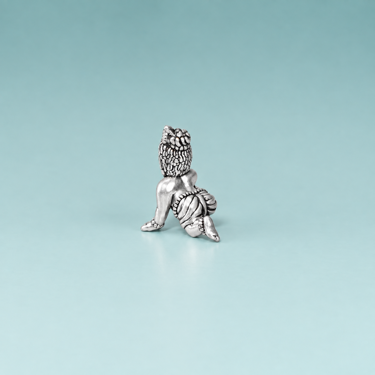 Back view of a silver crawling Laddu Gopal idol