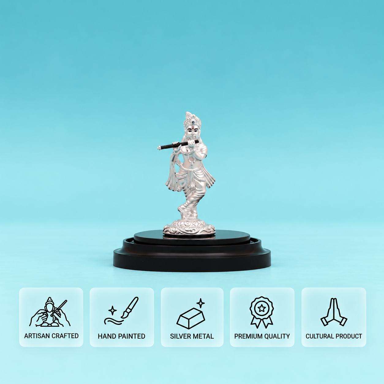 Front view of a silver Lord Krishna idol playing a flute on a round black base against a light blue background.