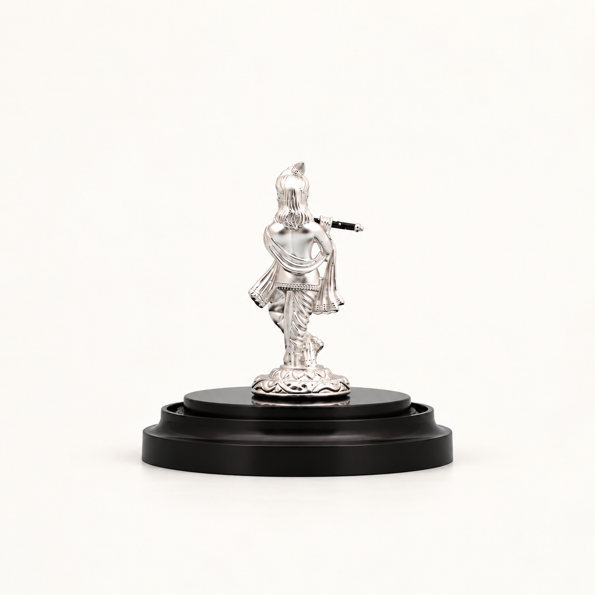 Back view of a silver Lord Krishna idol playing a flute, mounted on a round black wooden pedestal base.
